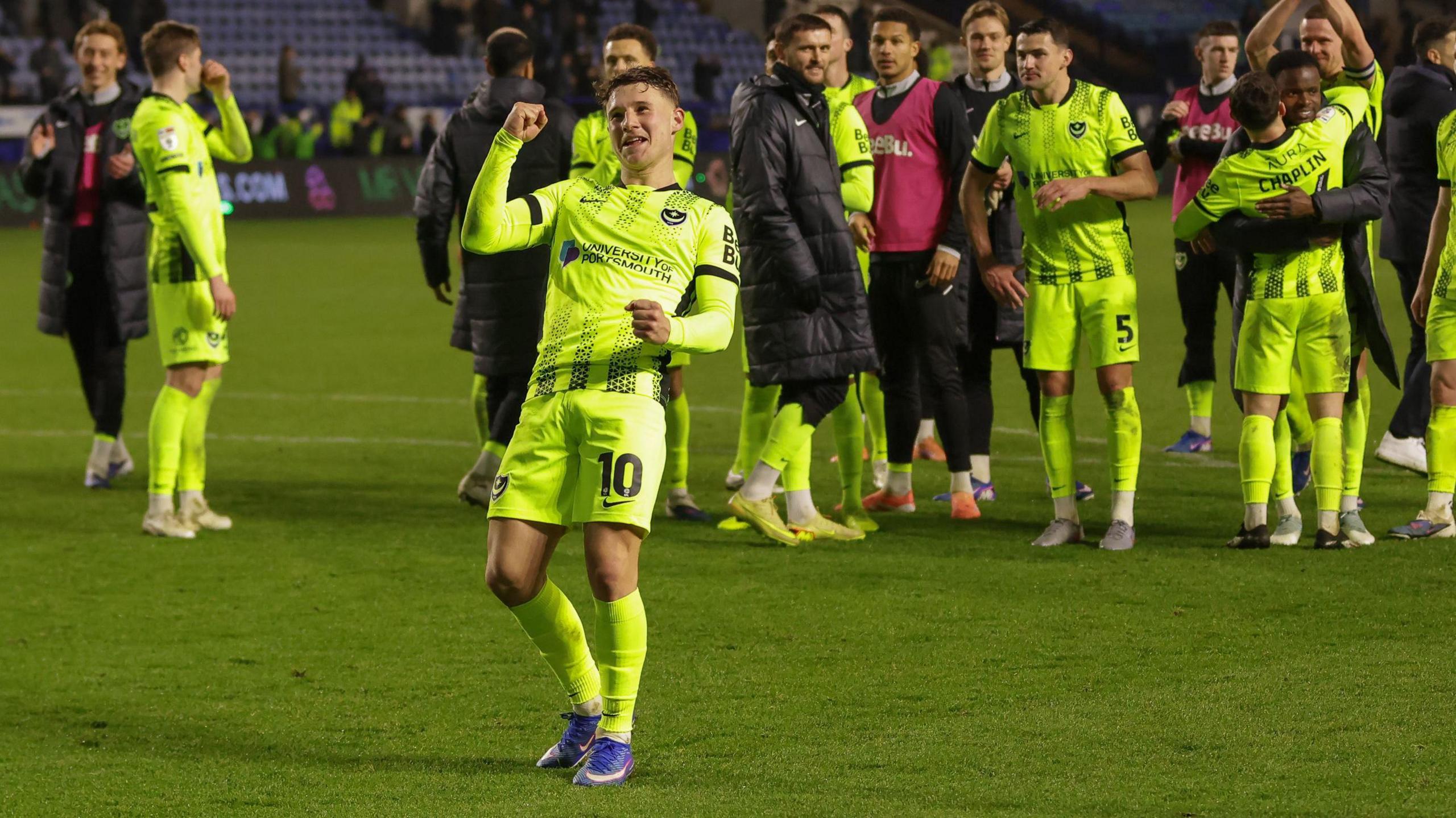 Adrian Segecic holding his fist up in celebration as his fellow Portsmouth team-mates gather behind him following their win against Sheffield Wednesday