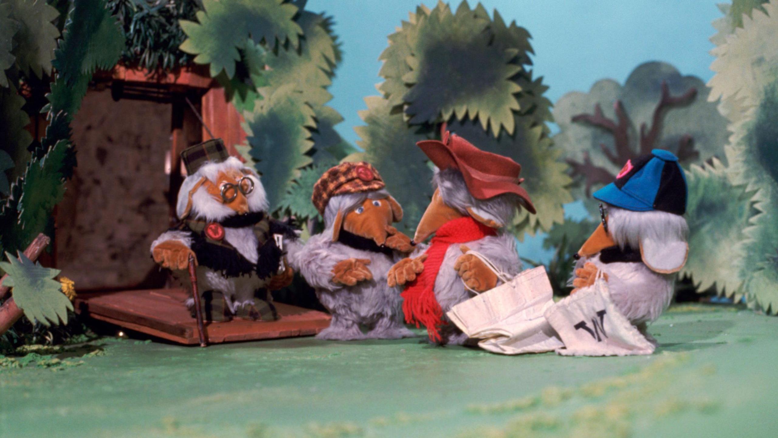 A scene taken from The Wombles' TV show where four Wombles are seen interacting outside. 