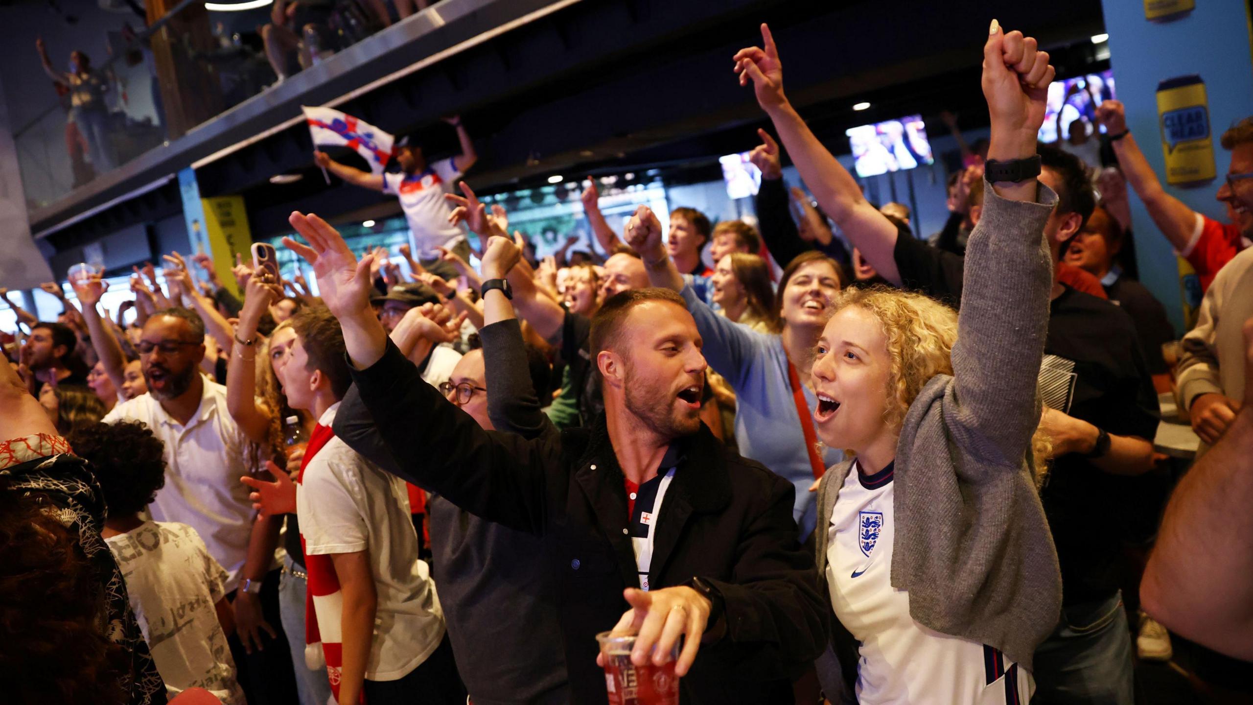 Dozens of fans in the sports bar at Ashton Gate Stadium cheer and clap as England's women win the Euros final