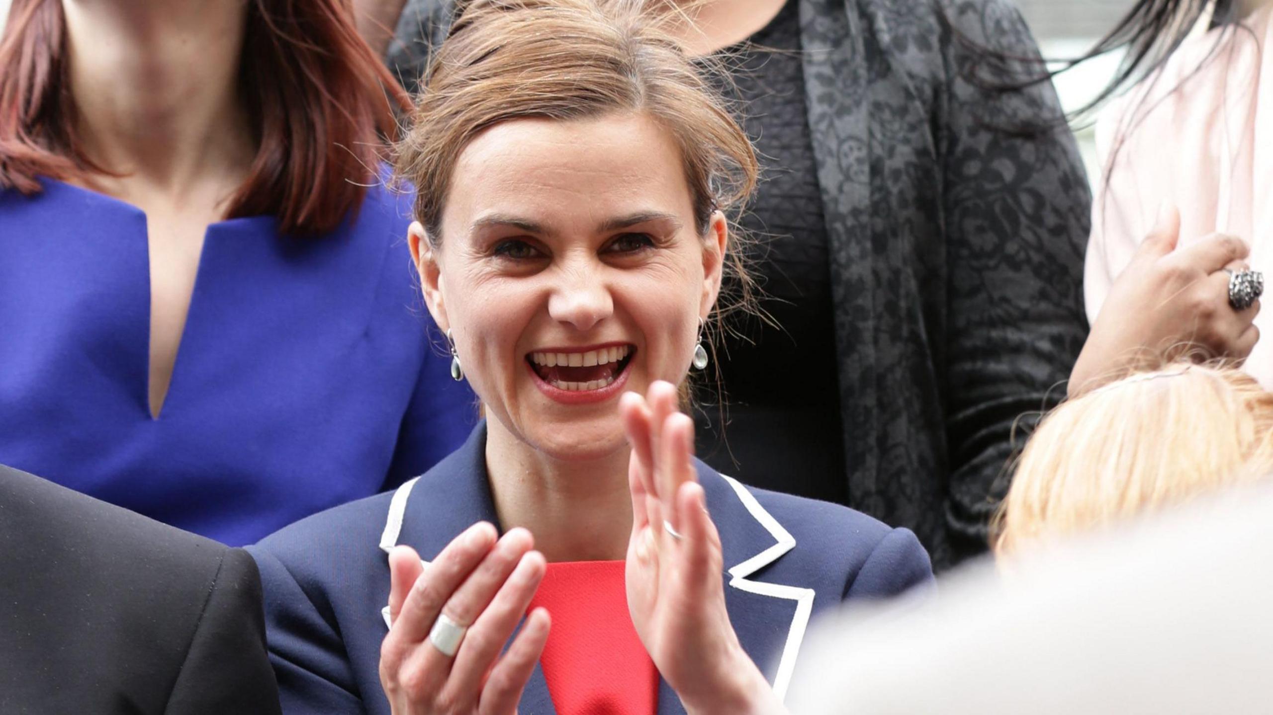 Jo Cox smiling and clapping in a crowd of people