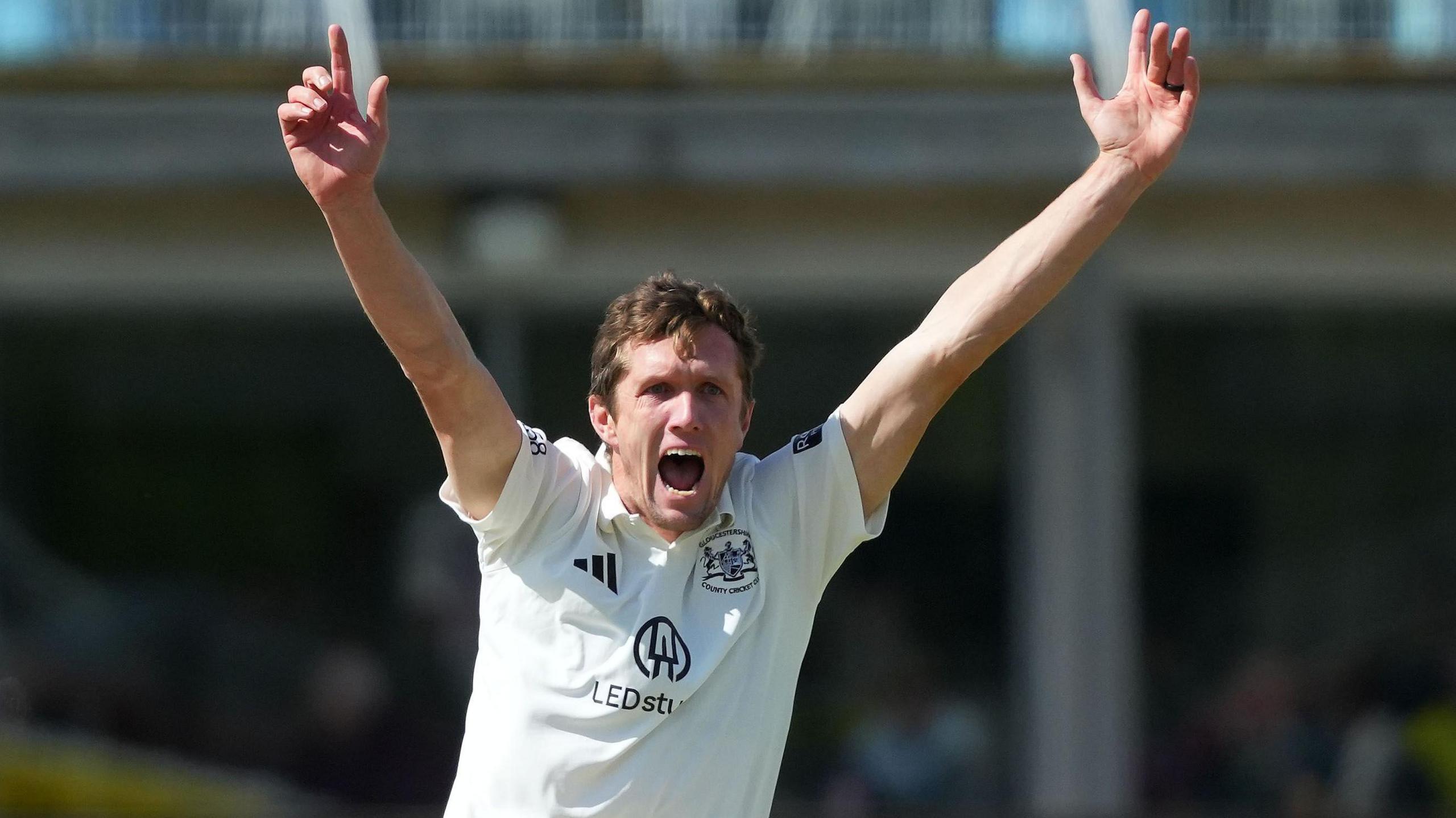 Will Williams with both hands aloft appealing for a wicket for Glocuestershire