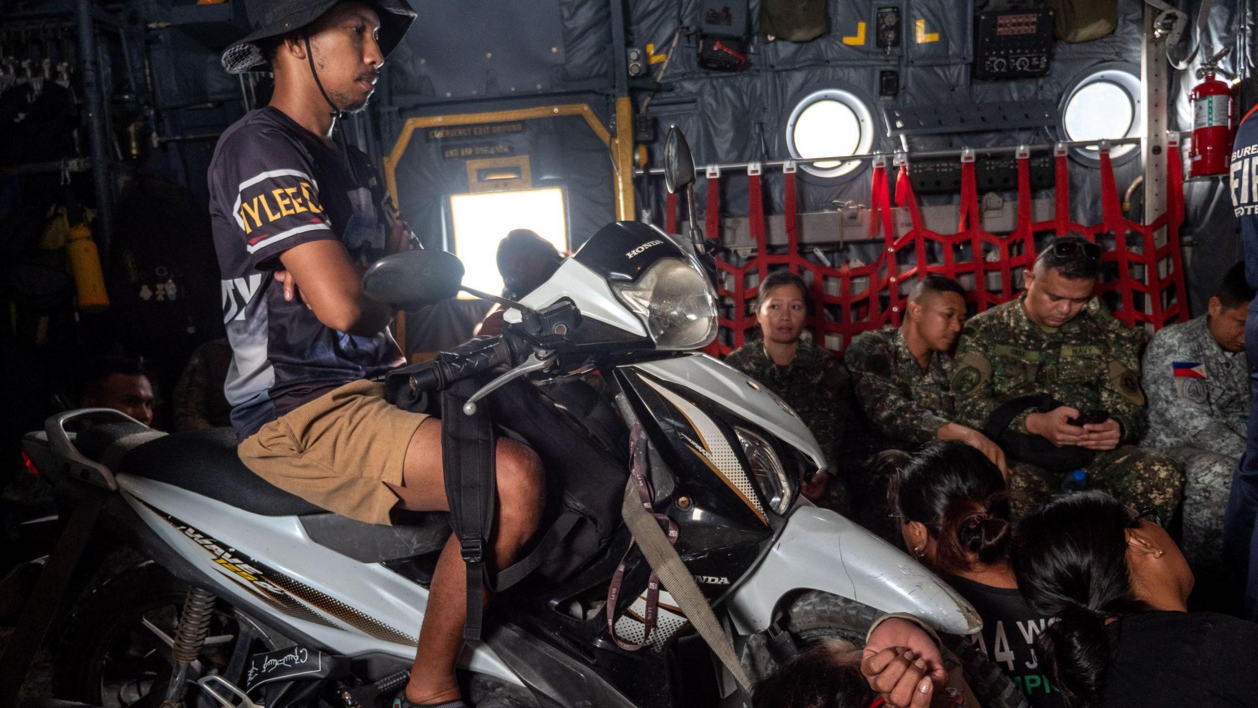 A man sits on a motorbike during a flight to Pagasa