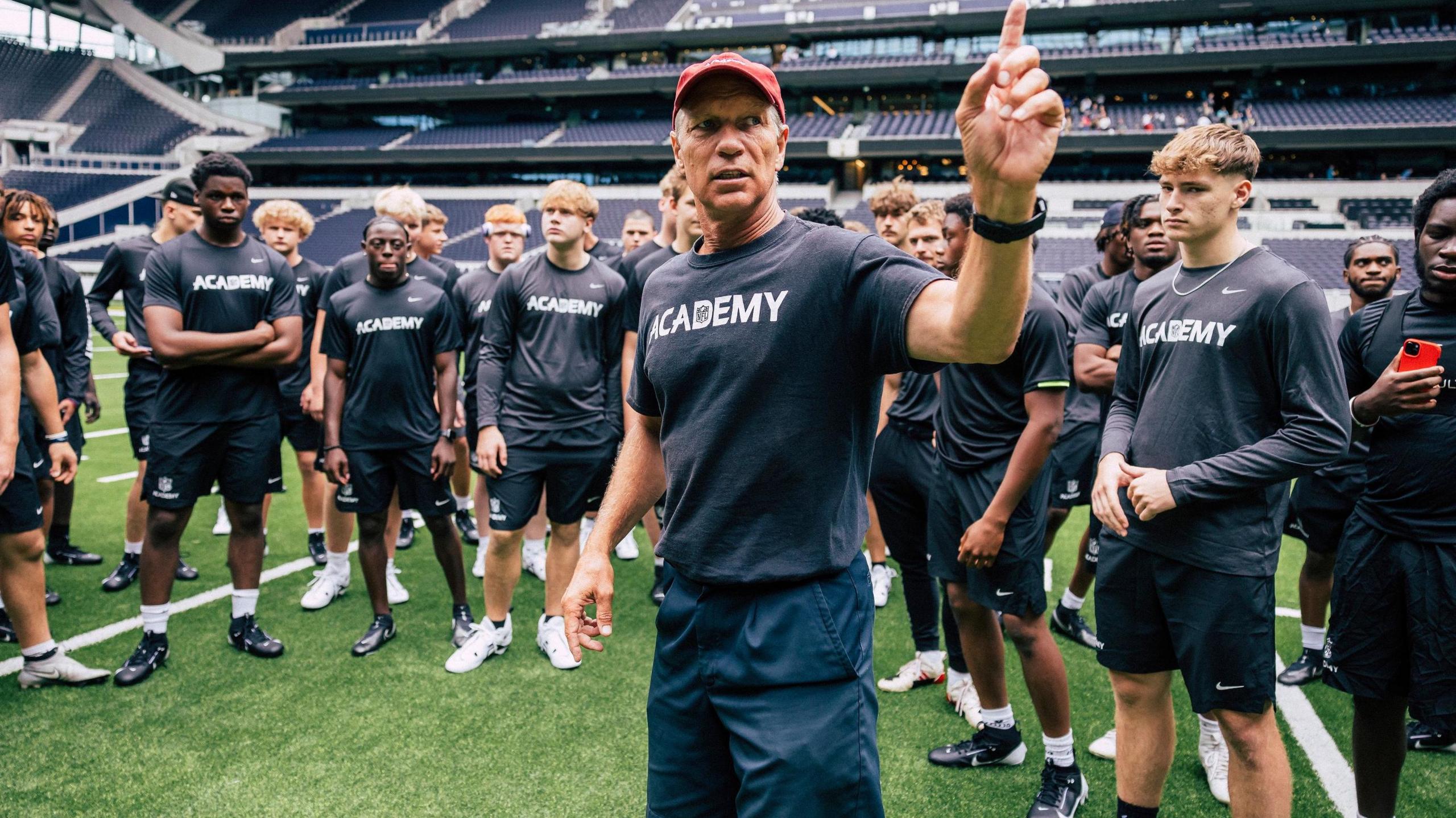 Head coach Steve Hagen addresses the NFL Academy on the pitch at Tottenham Hotspur Stadium 