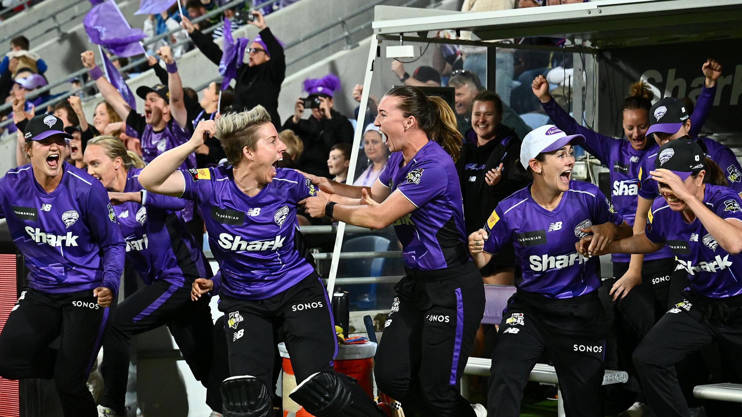 Hobart Hurricanes players celebrate in the dugout after winning the 2025 WBBL title