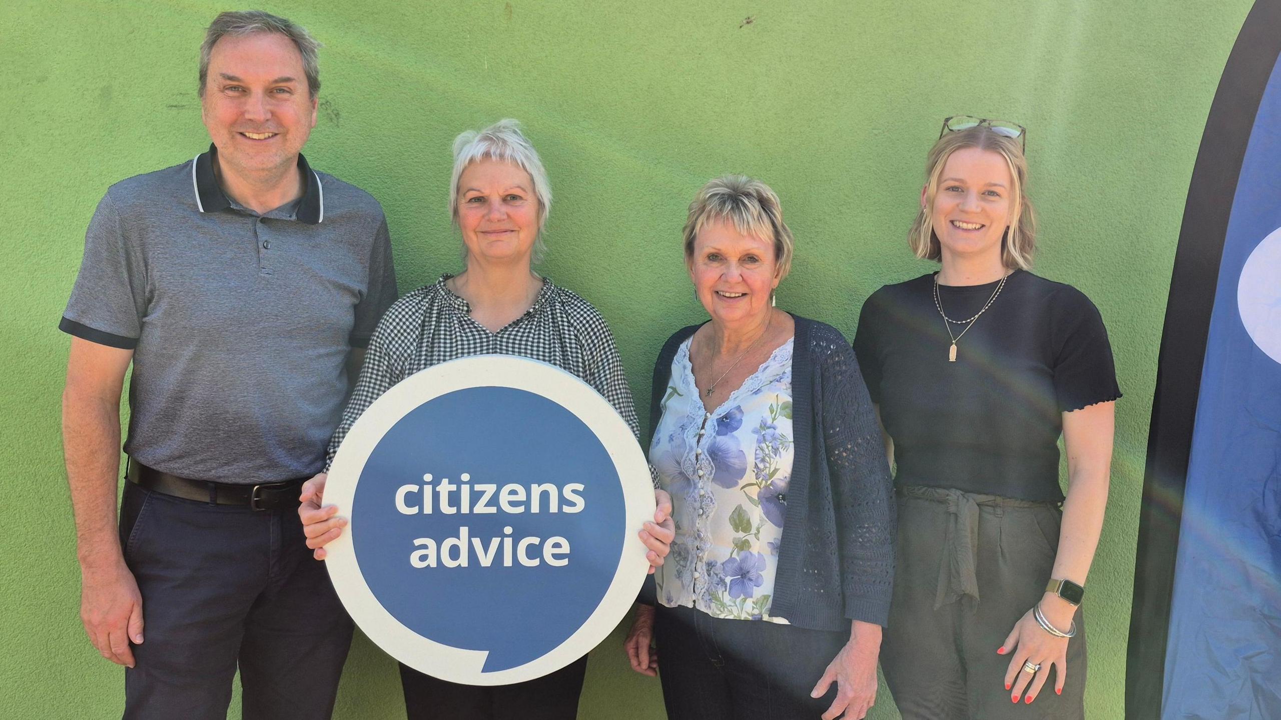 Four people - three woman and a man - smile as they pose for the camera. They are from Citizen's Advice Bureau South Gloucestershire and are celebrating an award win