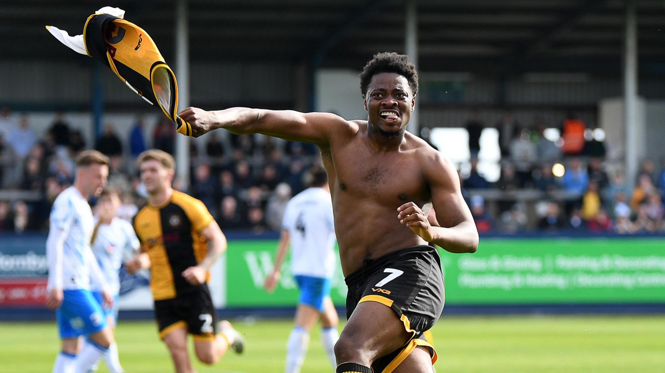 Bobby Kamwa celebrates his goal for Newport by taking off his shirt