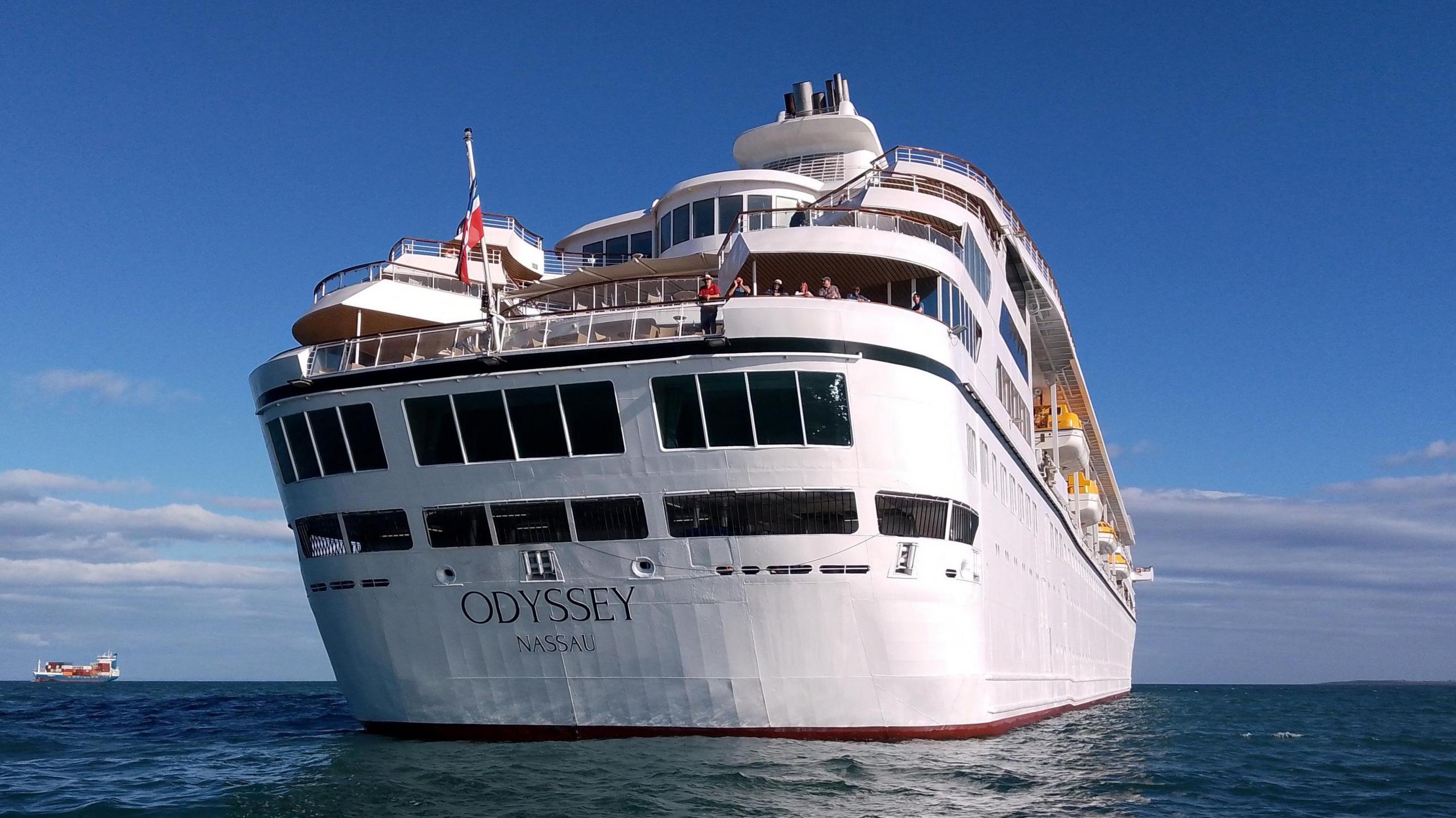 Stern of the Villa Vie Odyssey cruise ship off shore in Belfast lough on a sunny day. Passengers are looking overboard.