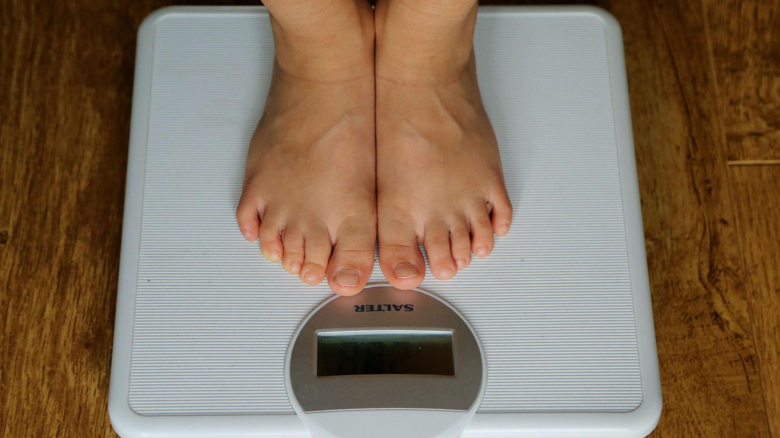 A young child's feet stood on weighing scales