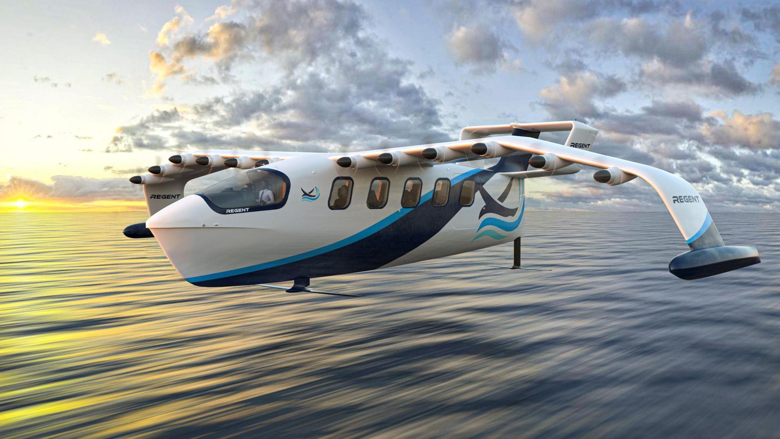 A visualisation of a Seaglider. It looks like an aircraft with curved wings and six small propellers on each wing. It has hydrofoils on its undercarriage and wings. The machine is shown flying low over the surface of the sea. The fuselage is painted white and blue and has five windows down its side.