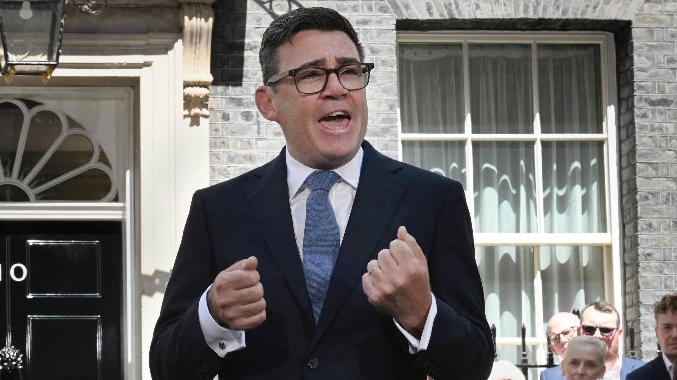 Andy Burnham make a fist with his hands as he delivers a speech outside 10 Downing Street