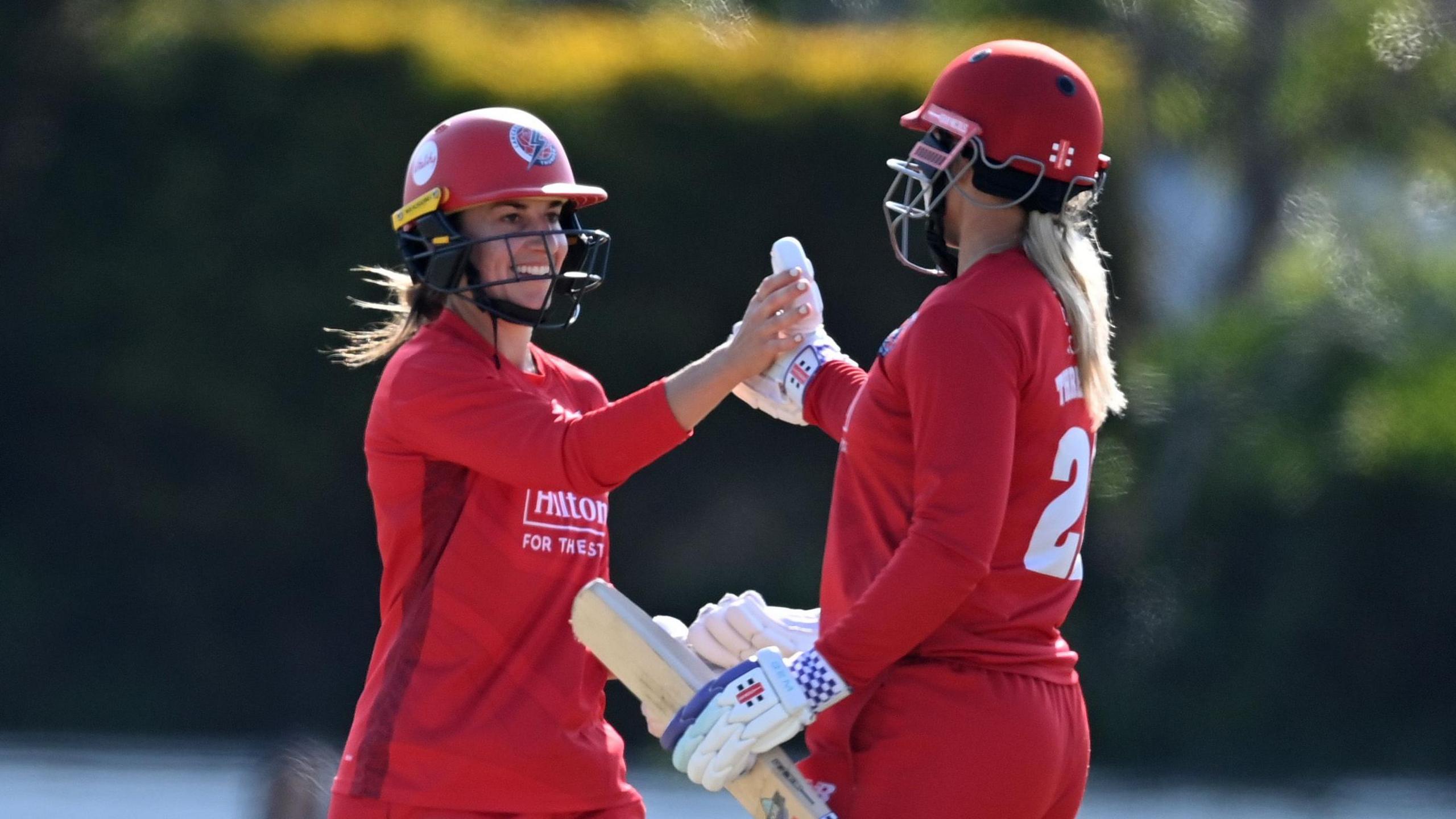 Fi Morris and Ellie Threlkeld slap hands after Lancashire beat Surrey in the One-Day Cup