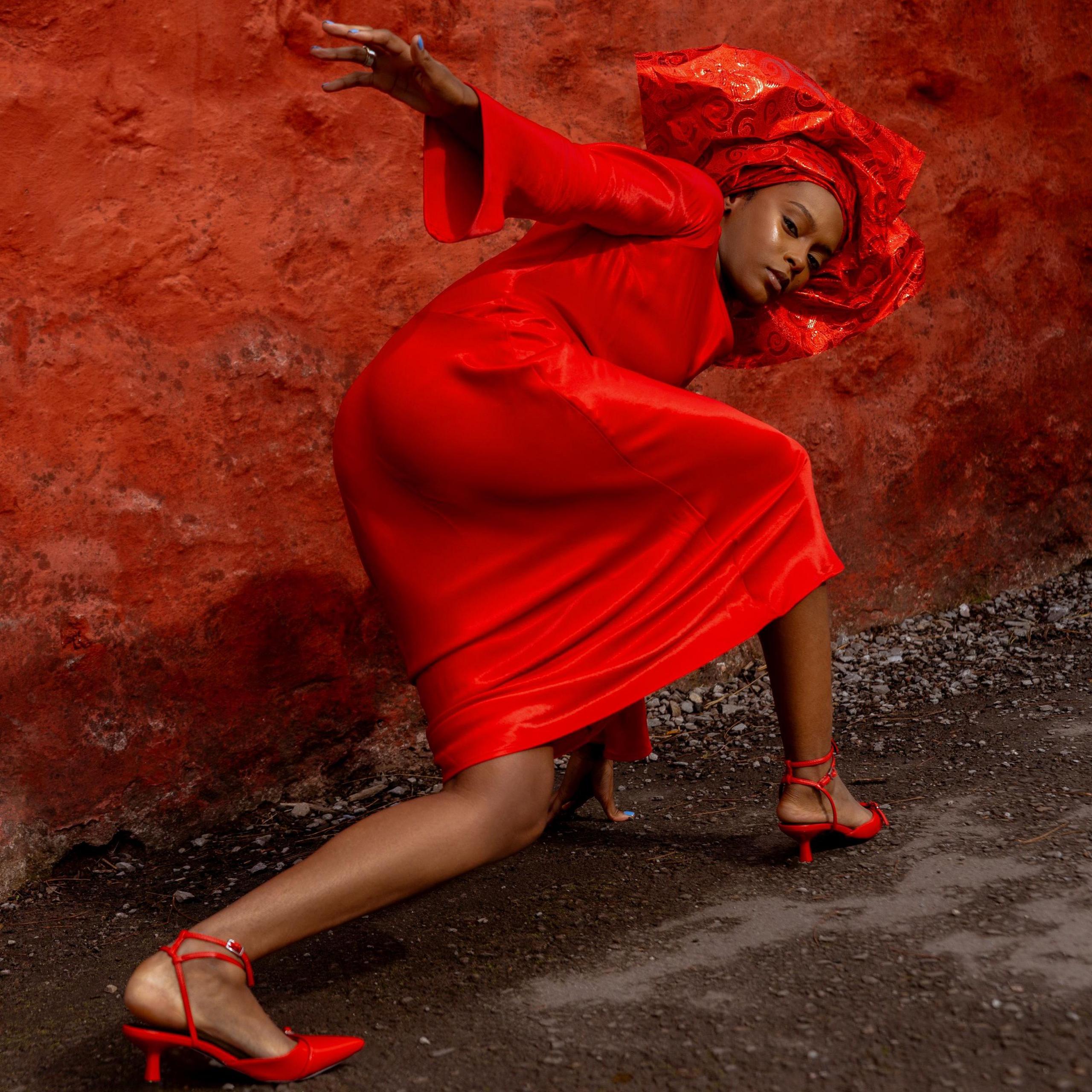 Dynes mewn ffrog a phenwisg goch