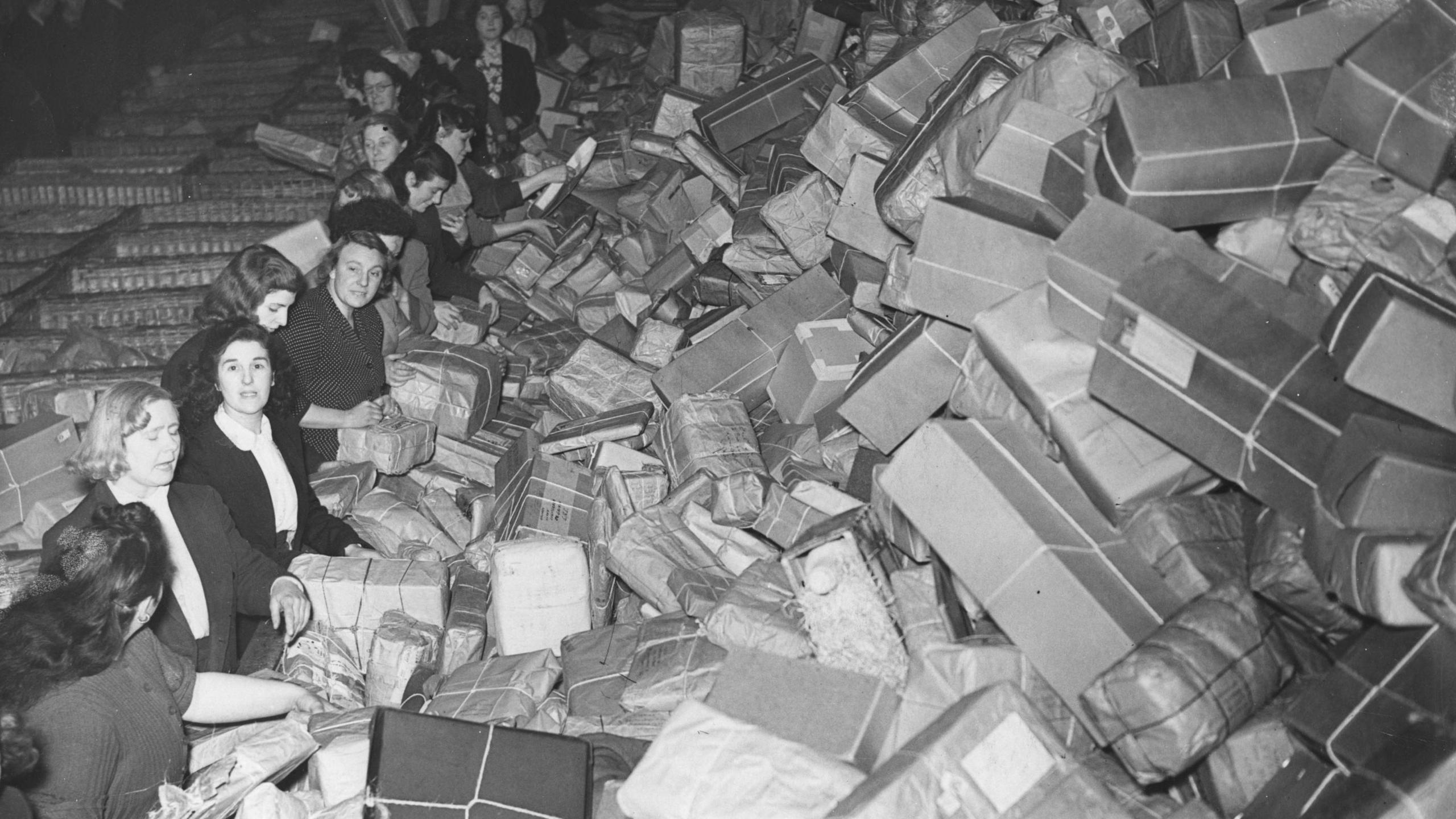 An enormous pile of parcels at Mount Pleasant Post Office, London, being sorted by some of the extra staff employed to cope with the Christmas rush, 1952. 