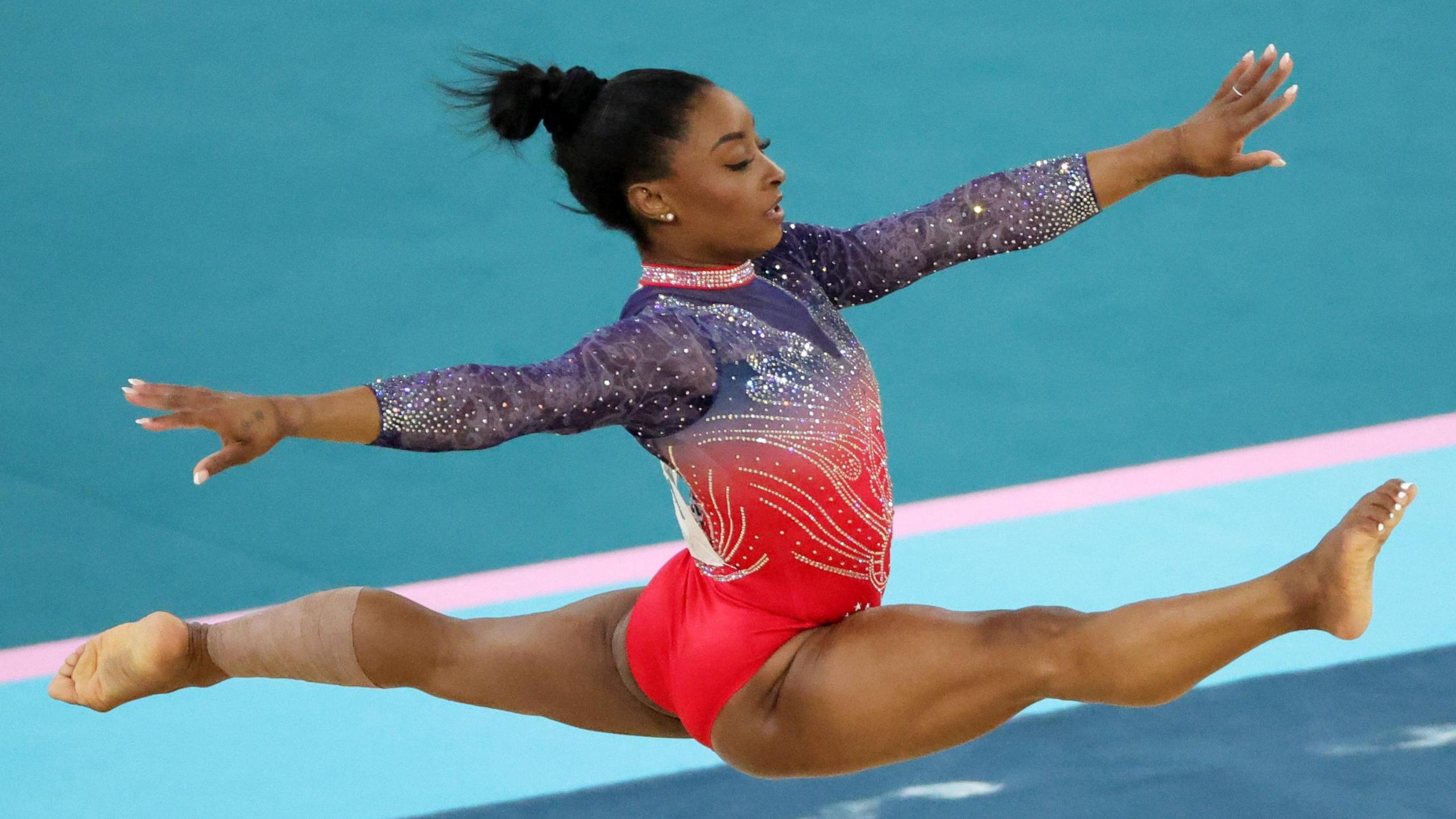 simone biles in the air doing the splits at the Paris 2024 olympics