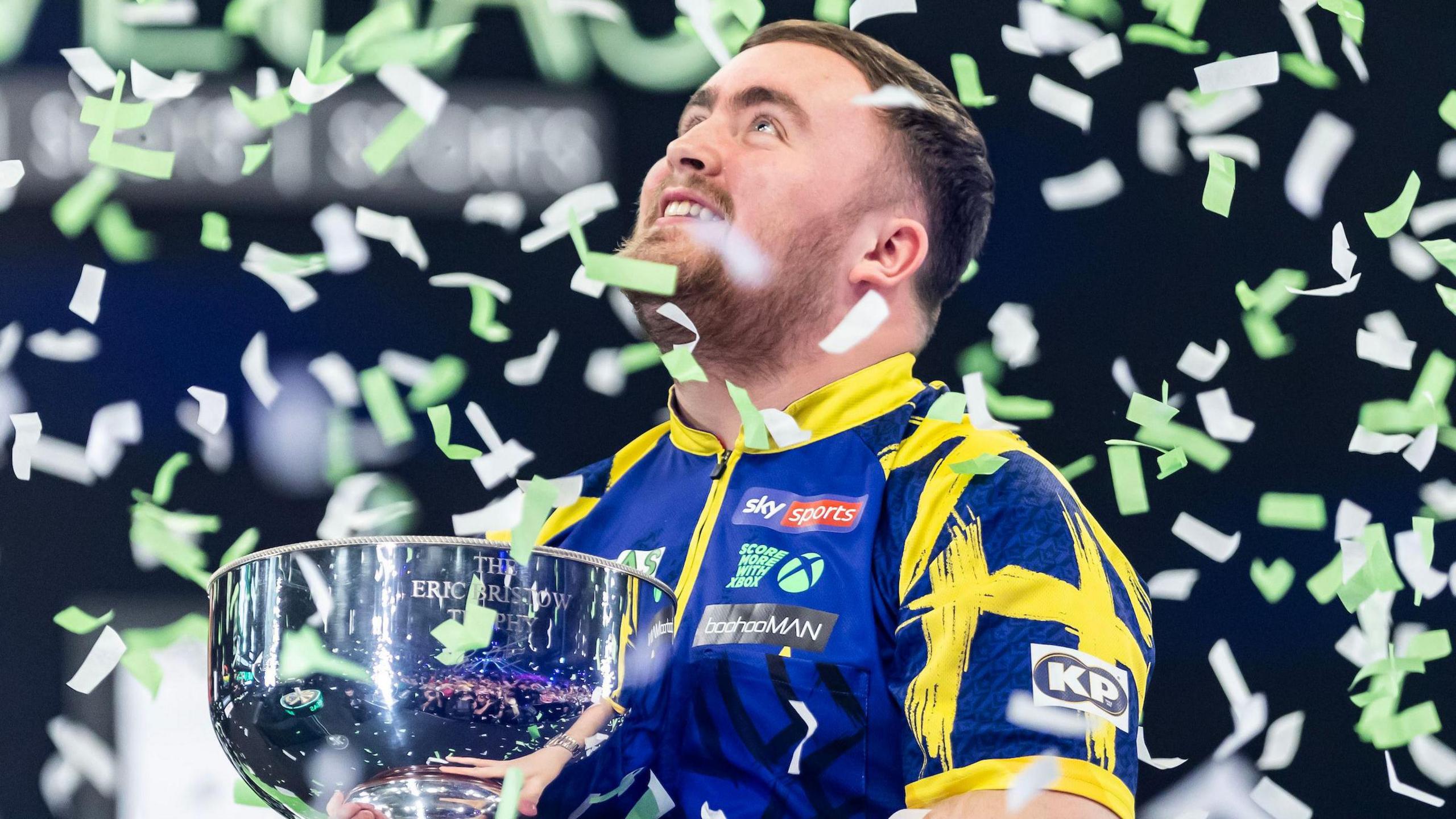 Luke Littler celebrates with Grand Slam of Darts trophy