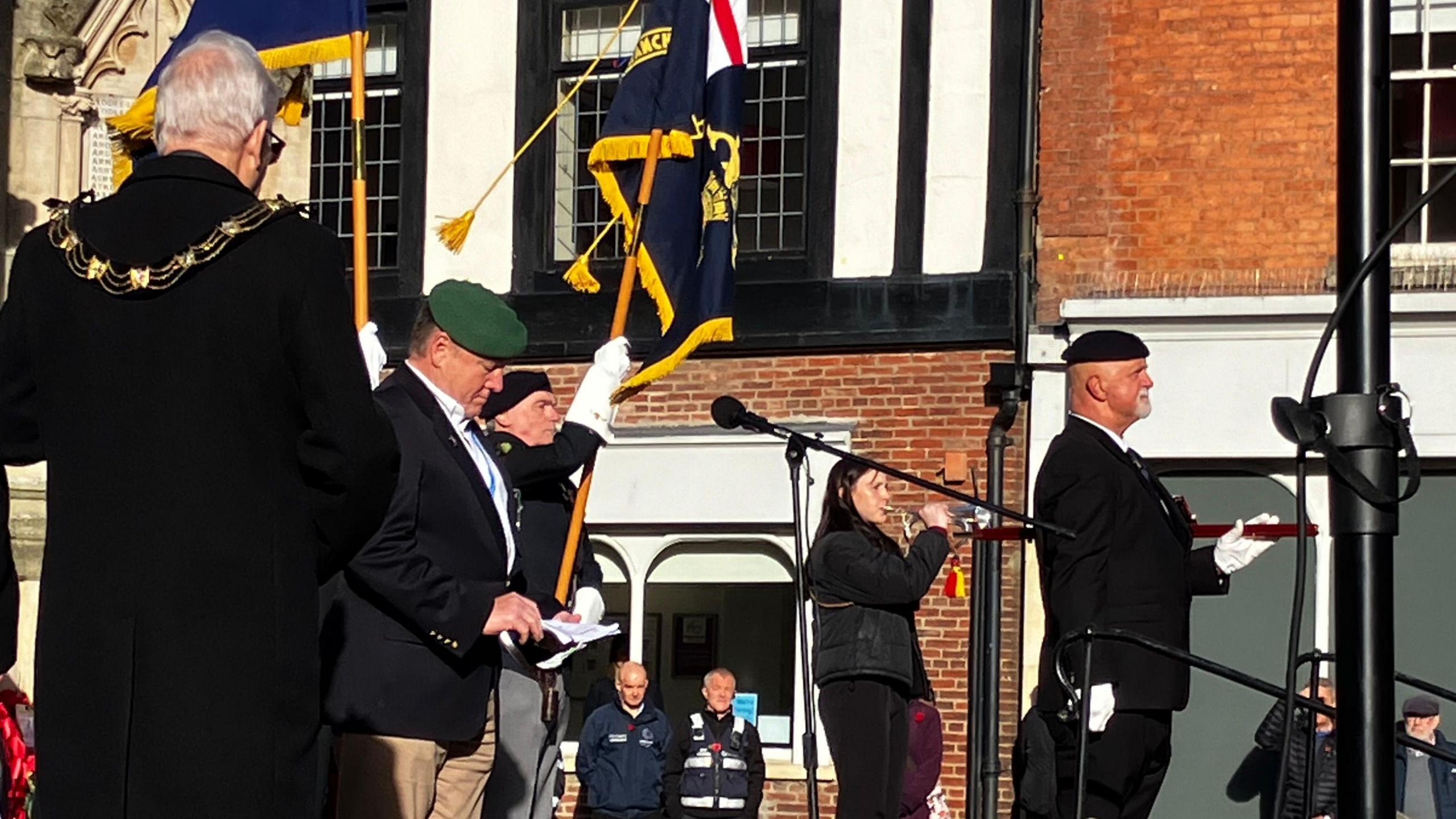 A bugler plays the Last Post as members of the Royal British Legion hold a flag ceremony in front of Lincoln's war memorial and honour scroll.