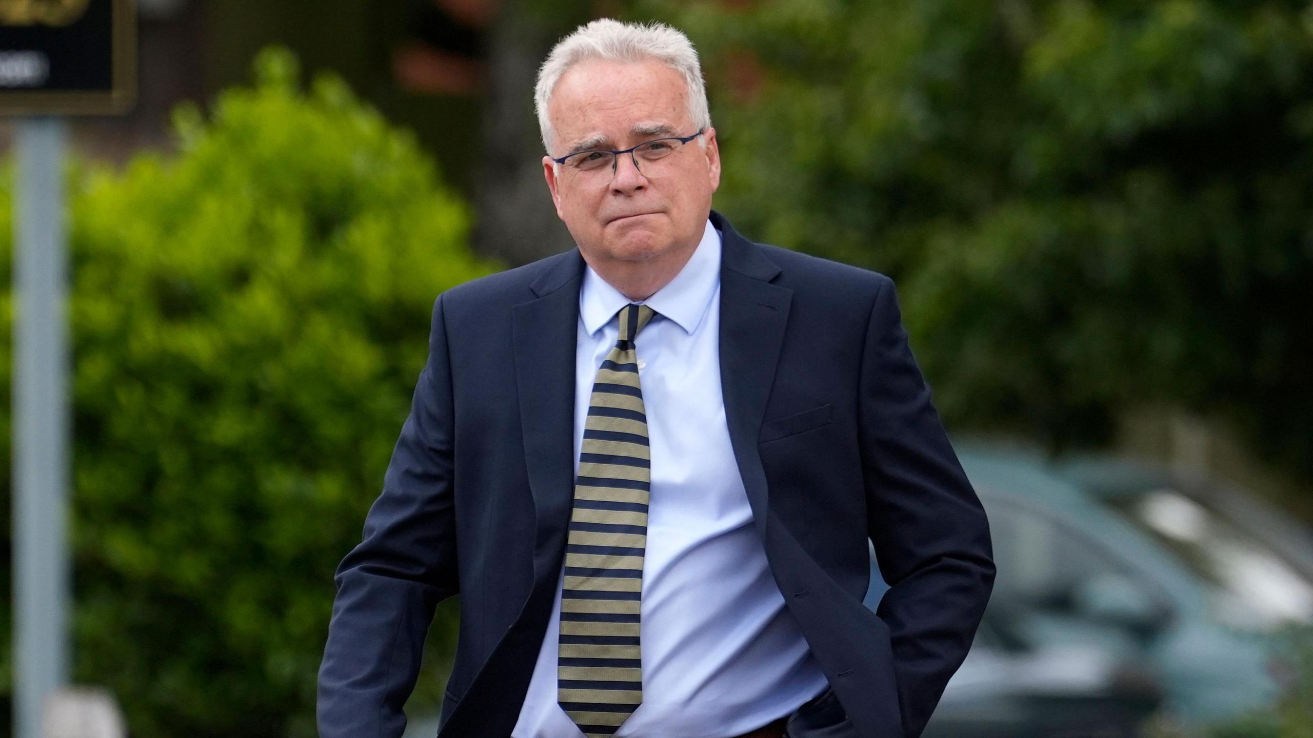 James Haviland walking into magistrates' court on Tuesday in a blue suit and a striped tie. He has white hair and glasses