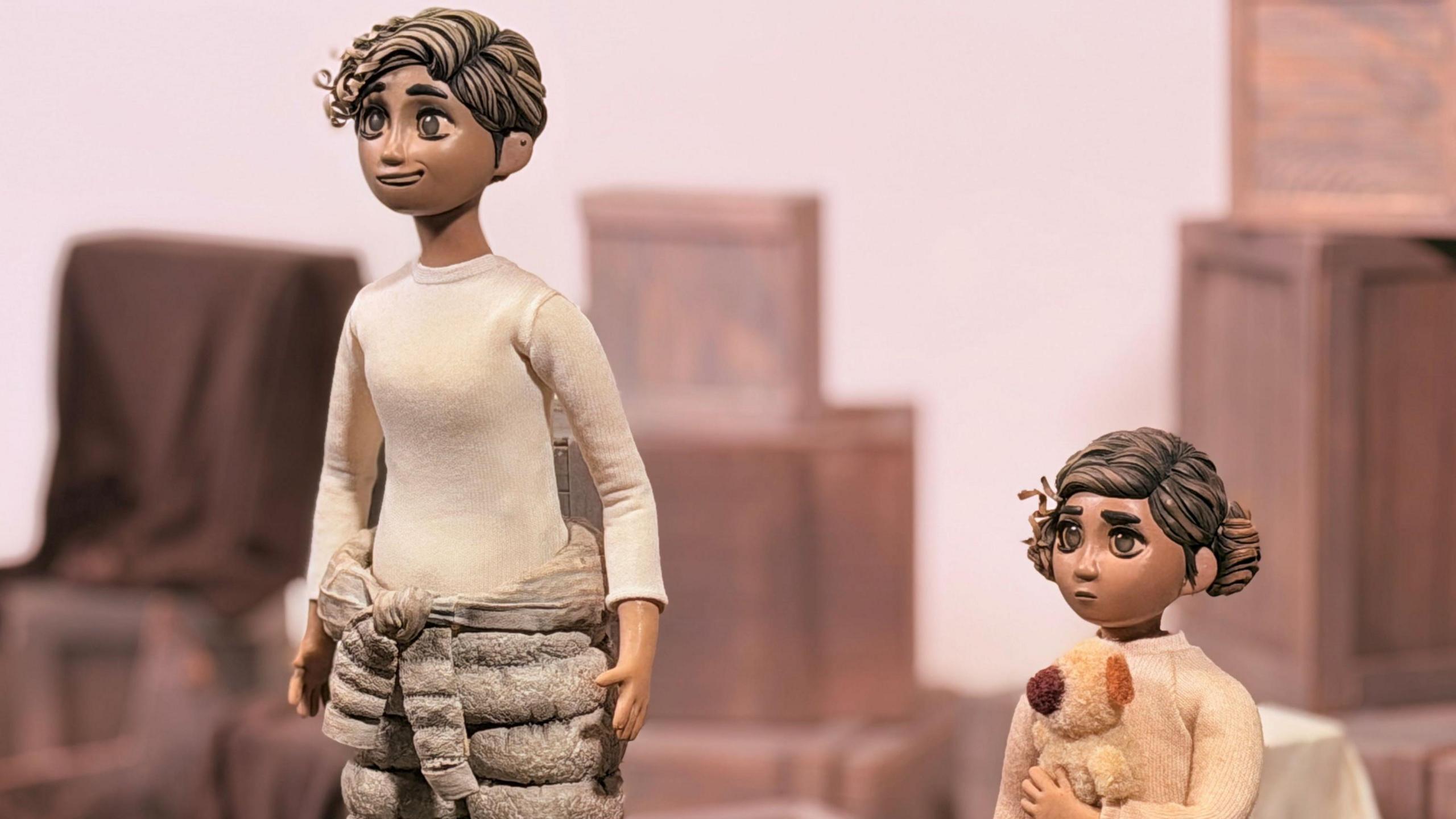 Prif gymeriadau'r ffilm. Mae gan gymeriad Rhi wallt byr, brown a chyrliog. Mae cymeriad y plentyn mewnol yn dal tedi