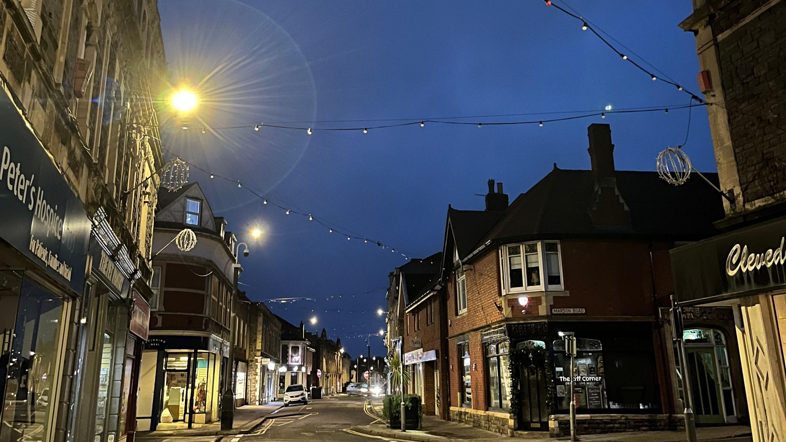 Image shows Clevedon town centre, with dim and underwhelming lights hung up around shops.