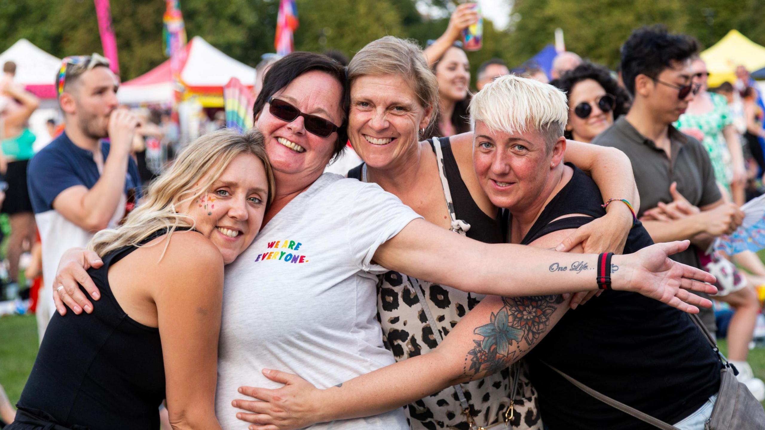 Four women hugging each other while they pose for a photo at Pride in Gloucestershire 2024