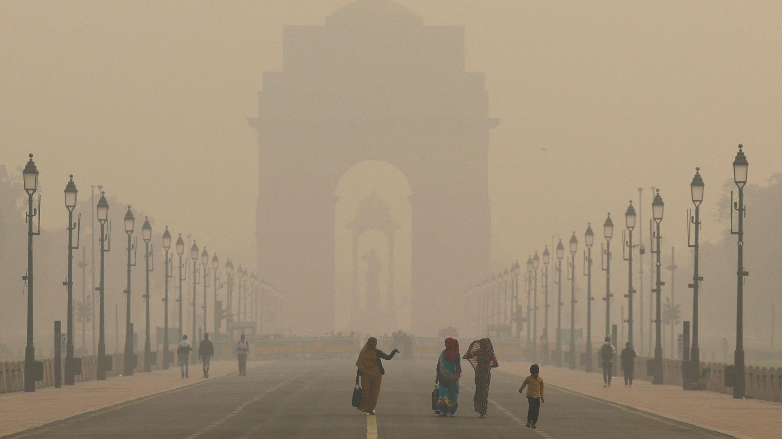 Women walk on a road near India Gate as the sky is enveloped with smog after Delhi's air quality worsened due to air pollution, in New Delhi, India, November 19, 2024. REUTERS/Anushree Fadnavis