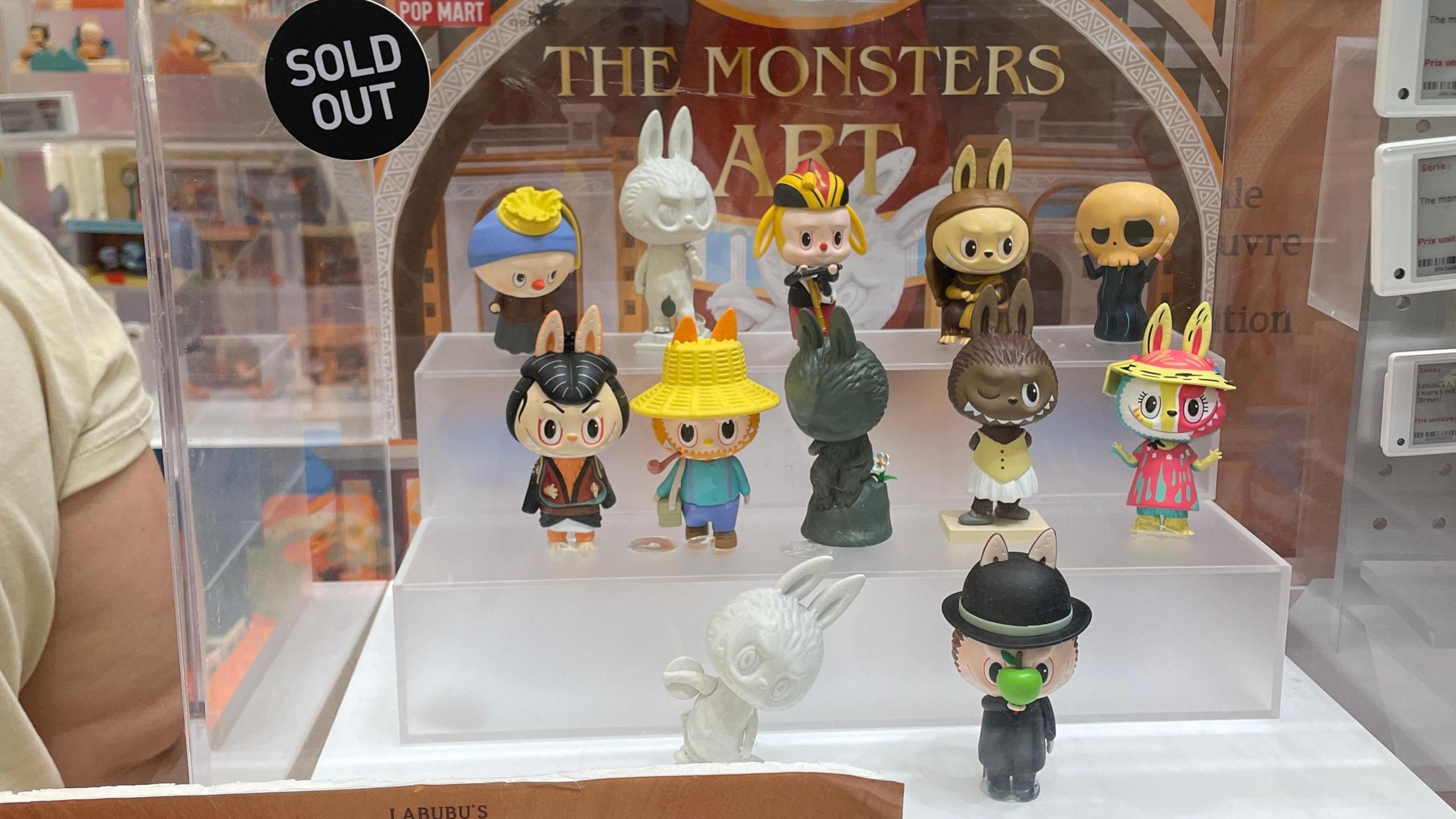Signs reading 'Sold Out' are seen on shelves displaying products of POP MART Labubu's Artistic Quest Limited Series.