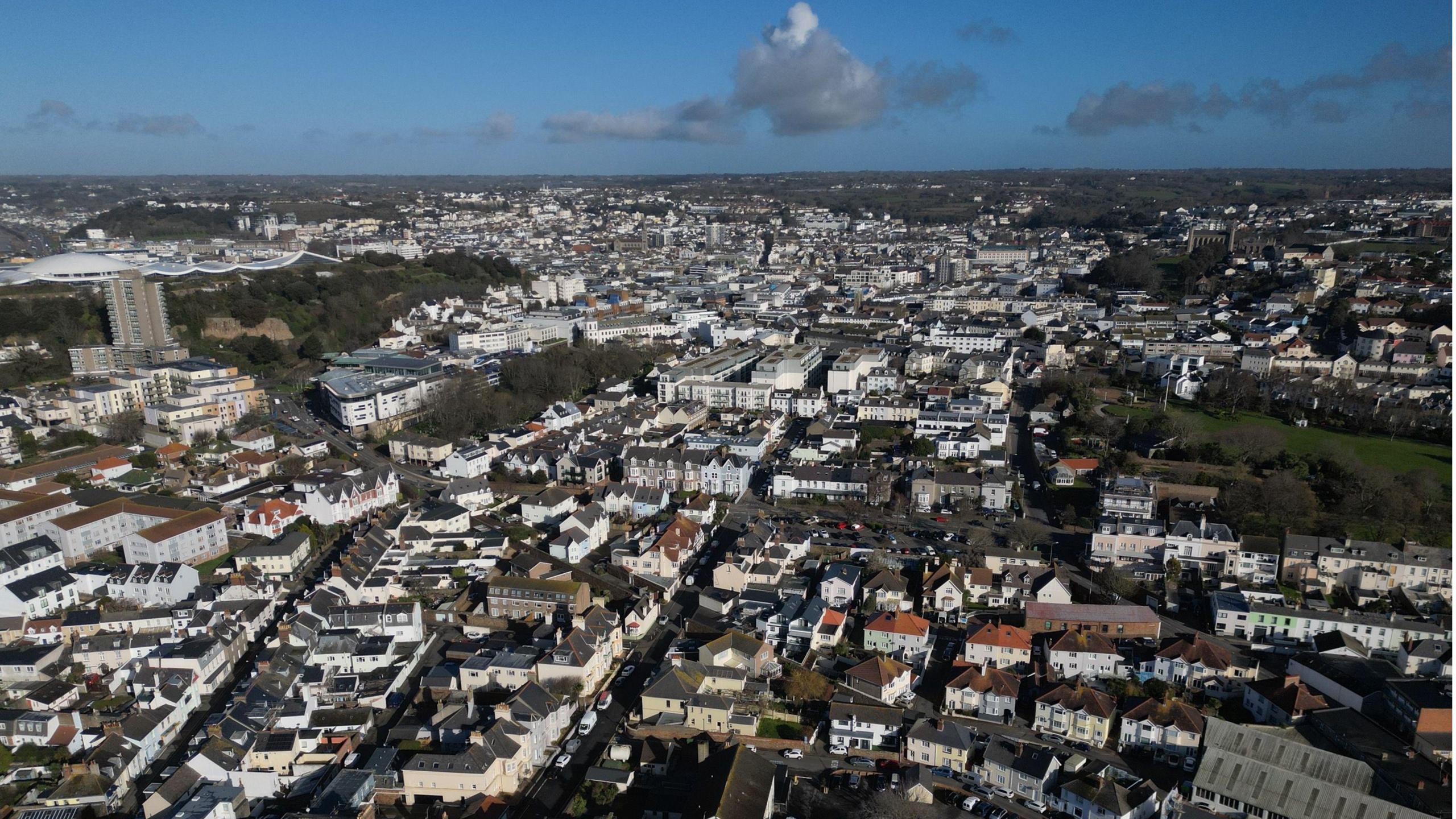 A drone picture of houses in Jersey under a blue sky.