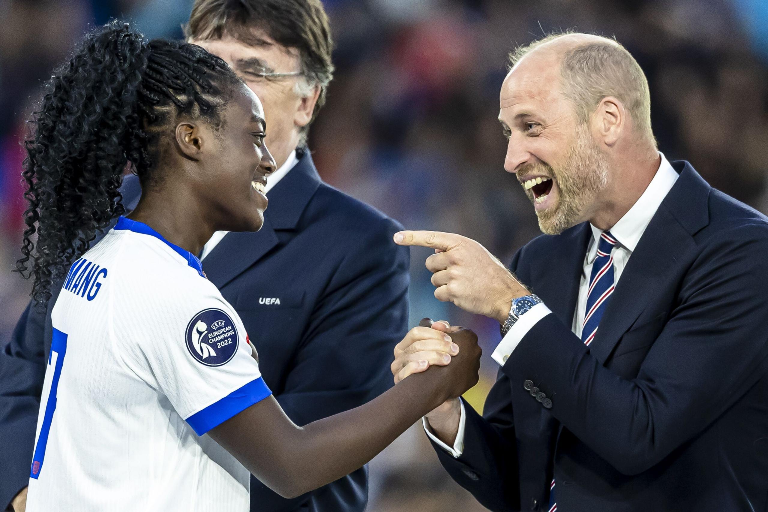 The Prince of Wales looks delighted while congratulating England's Michelle Agyemang shaking her hand and pointing a finger while she smiles back at him