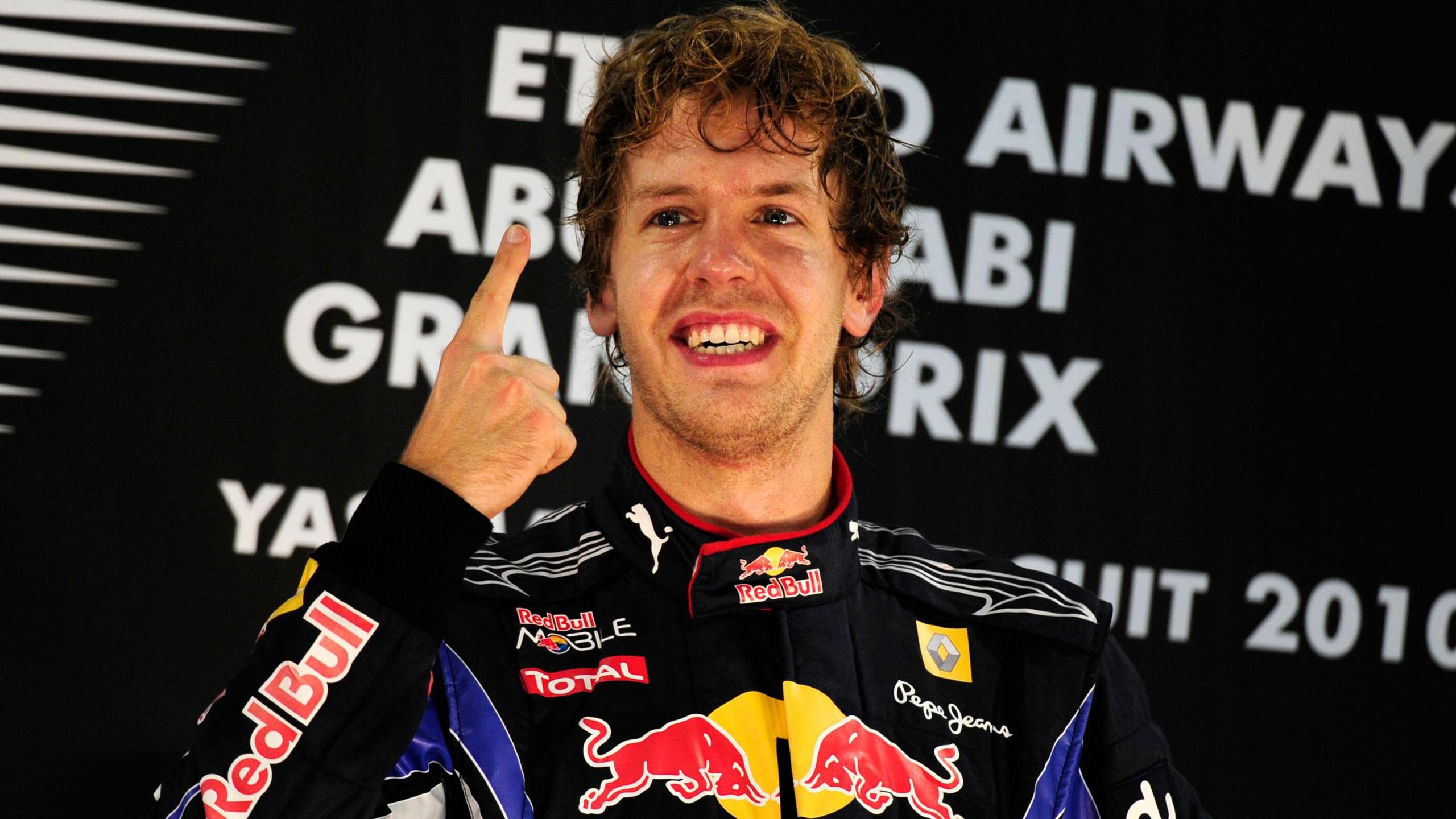 Sebastian Vettel lifts his right index finger in celebration on the podium after winning the 2010 Abu Dhabi Grand Prix and the drivers' championship