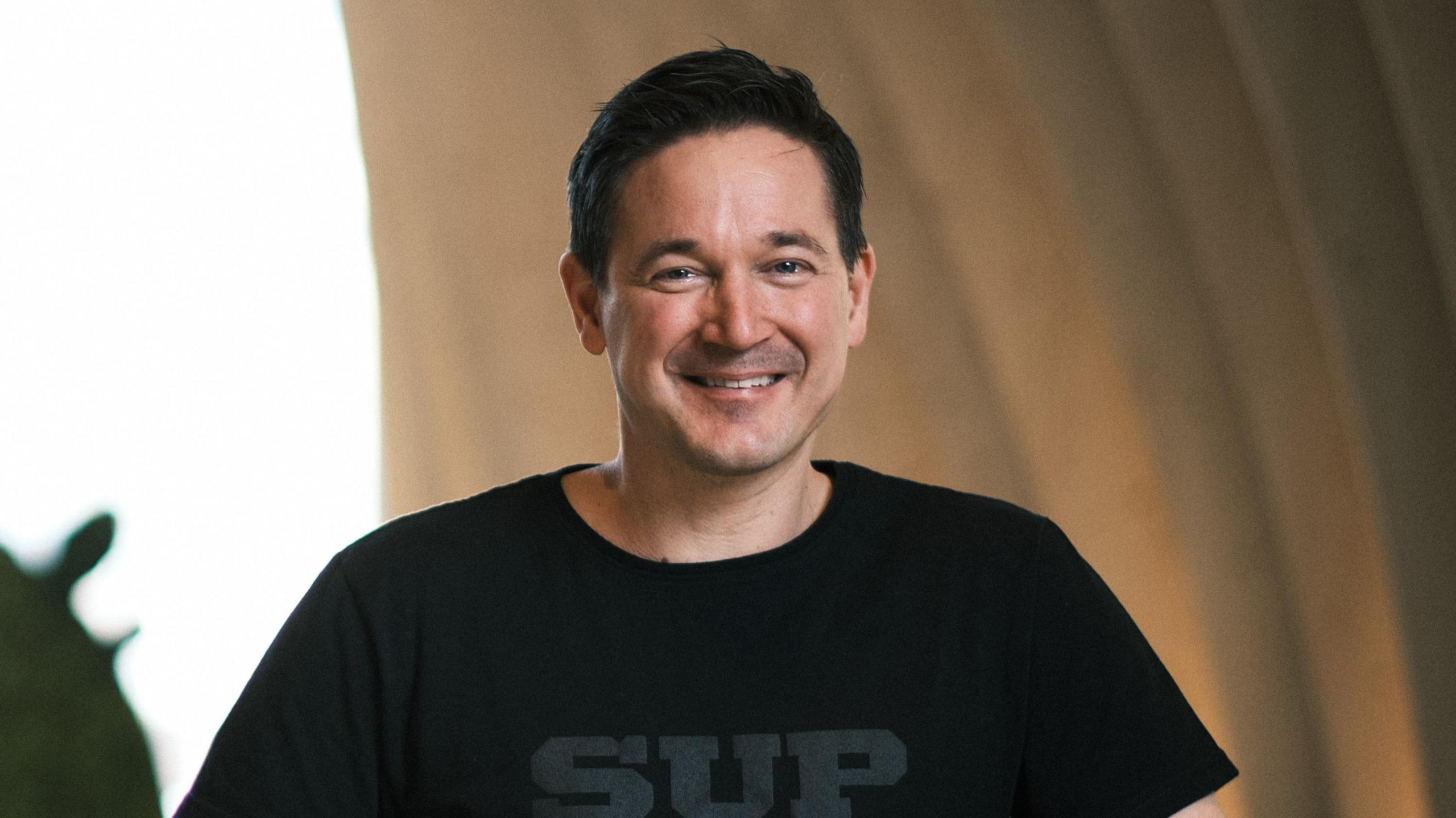 Ilkka Paananen smiling and wearing a black t-shirt