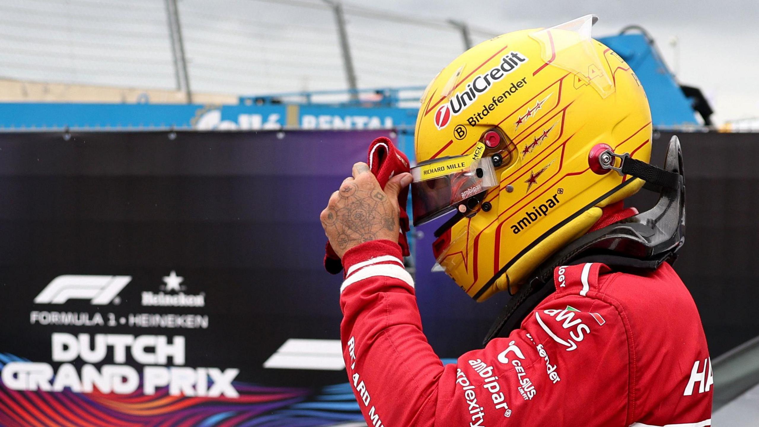 Lewis Hamilton adjusts his helmet visor after retiring form the Dutch Grand Prix