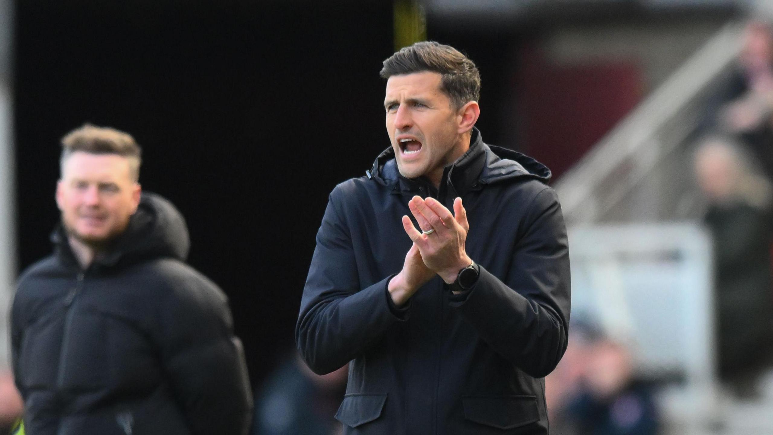 Portsmouth manager John Mousinho applauds his players from the touchline at Middlesbrough.