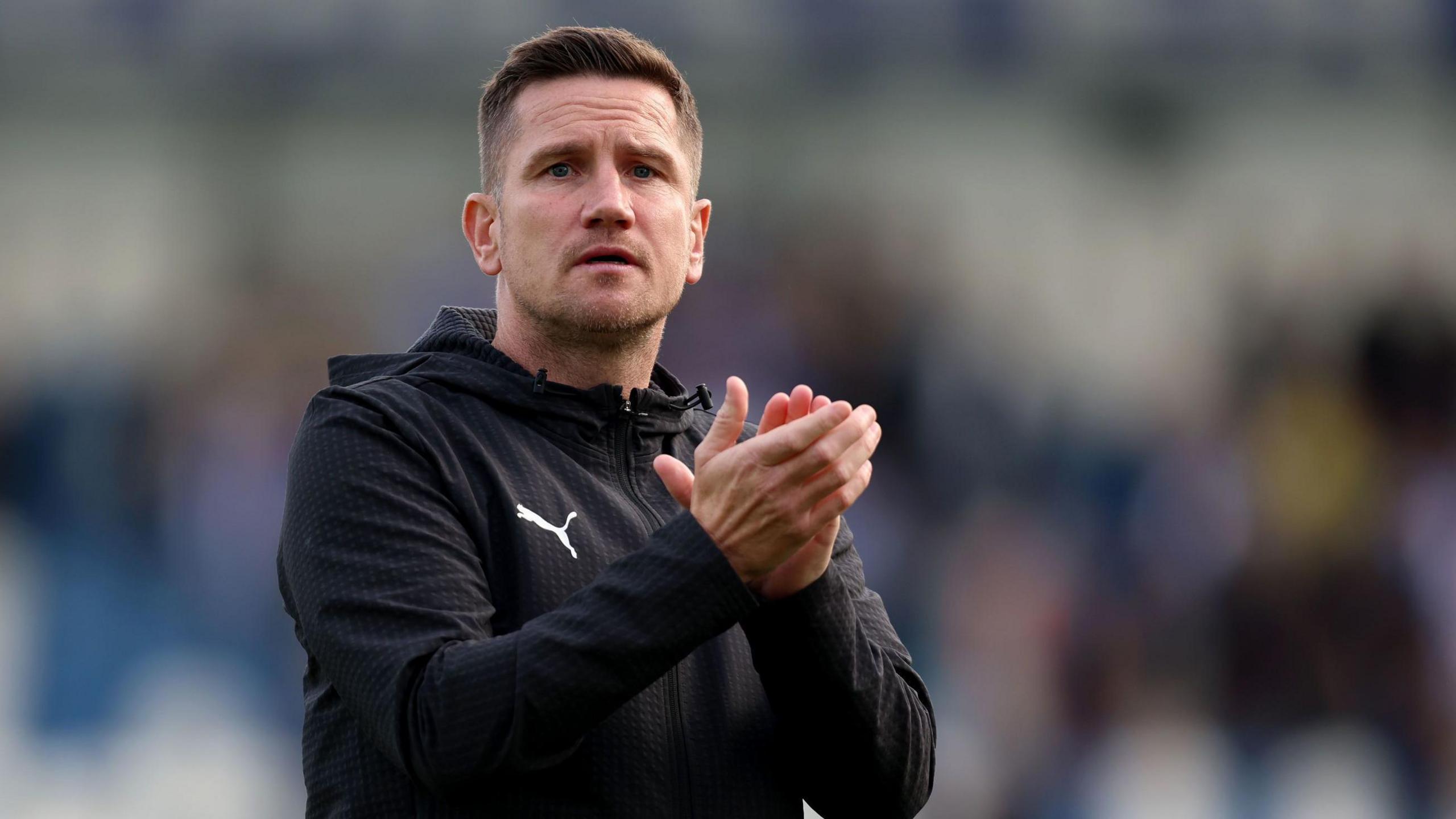 Crewe boss Lee Bell applauds the crowd after a game.