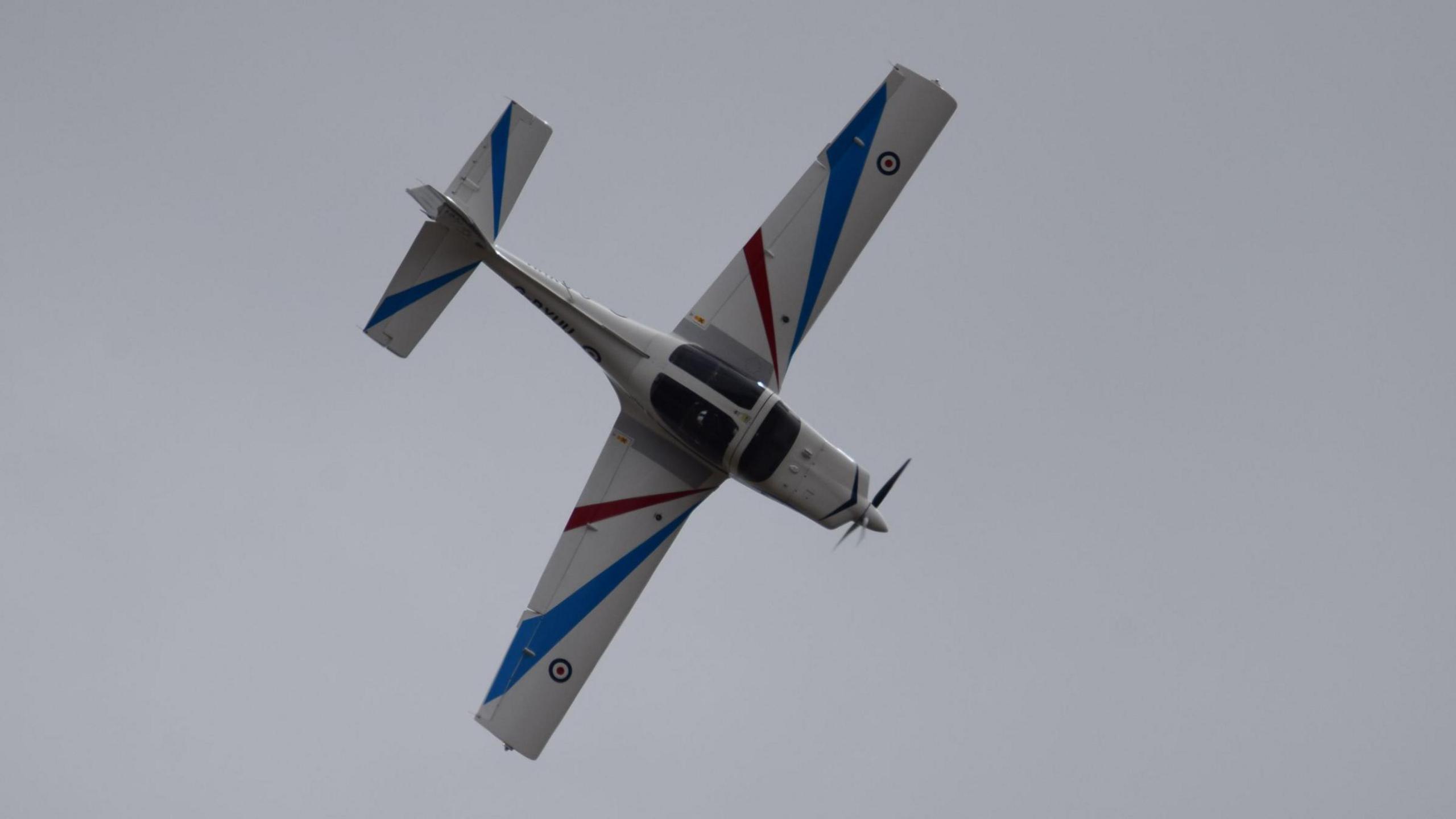 A small RAF plane which is white with red and blue stripes on its wings and tail.