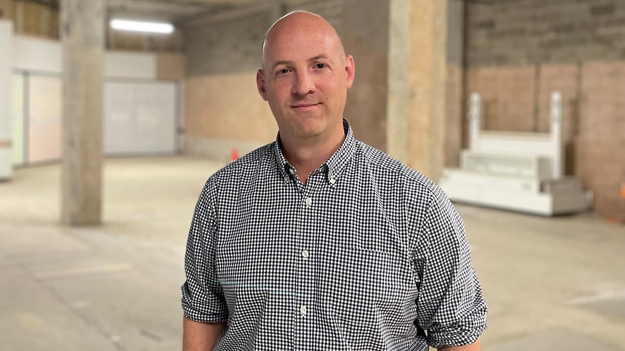 Liam Greenwood, the bald-headed centre manager, stands in an empty unfinished space