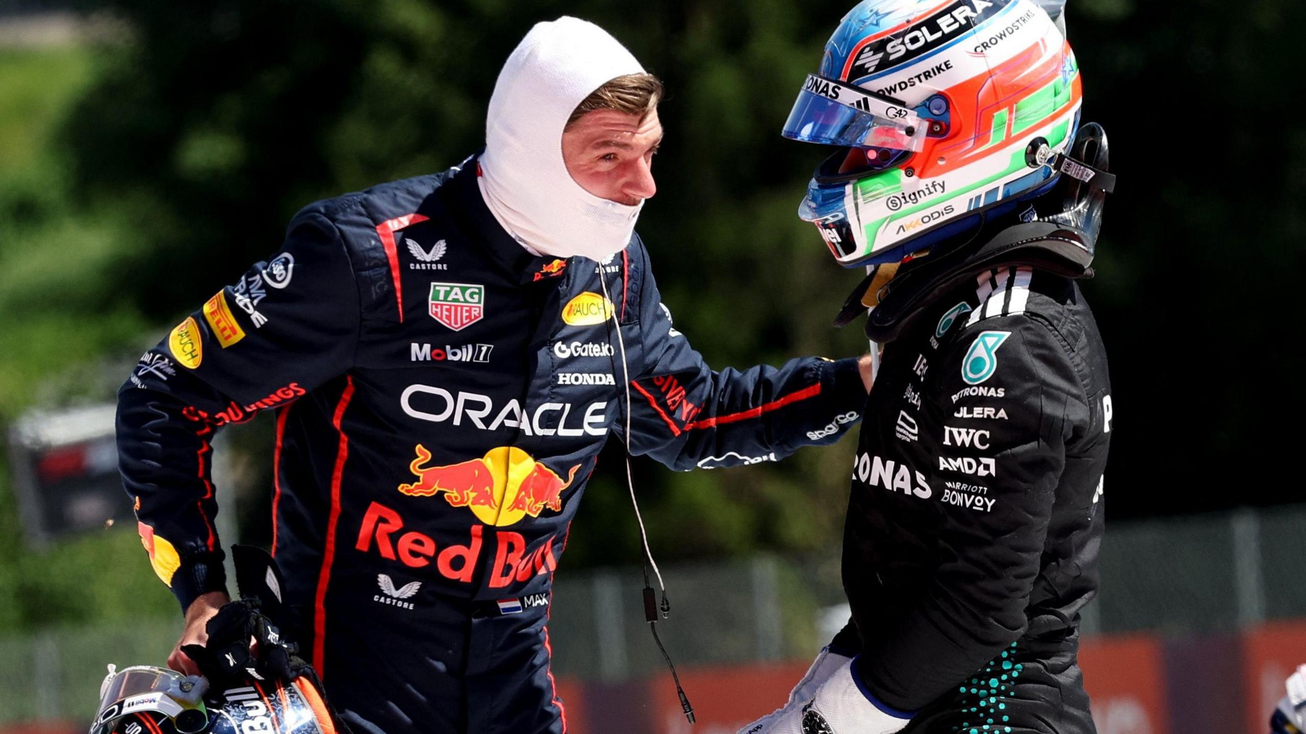 Max Verstappen speaking to Kimi Antonelli with his arm on the Italian's shoulder after both drivers retired from the Austrian Grand Prix