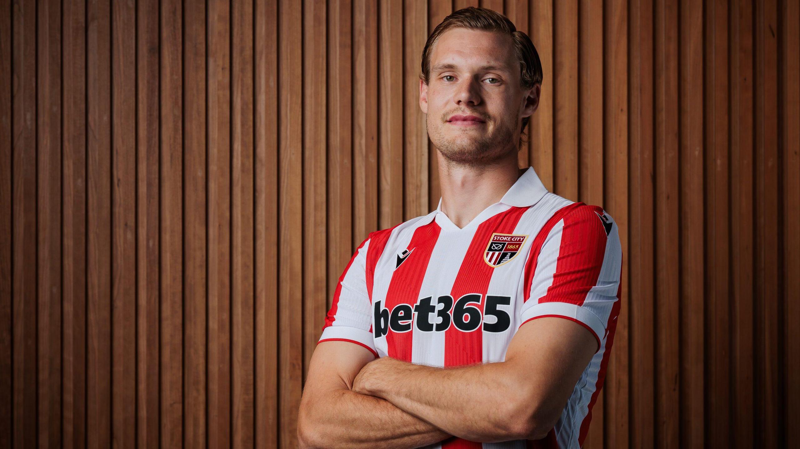 Svante Ingelsson folds his arms in a Stoke City red-and-white striped shirt
