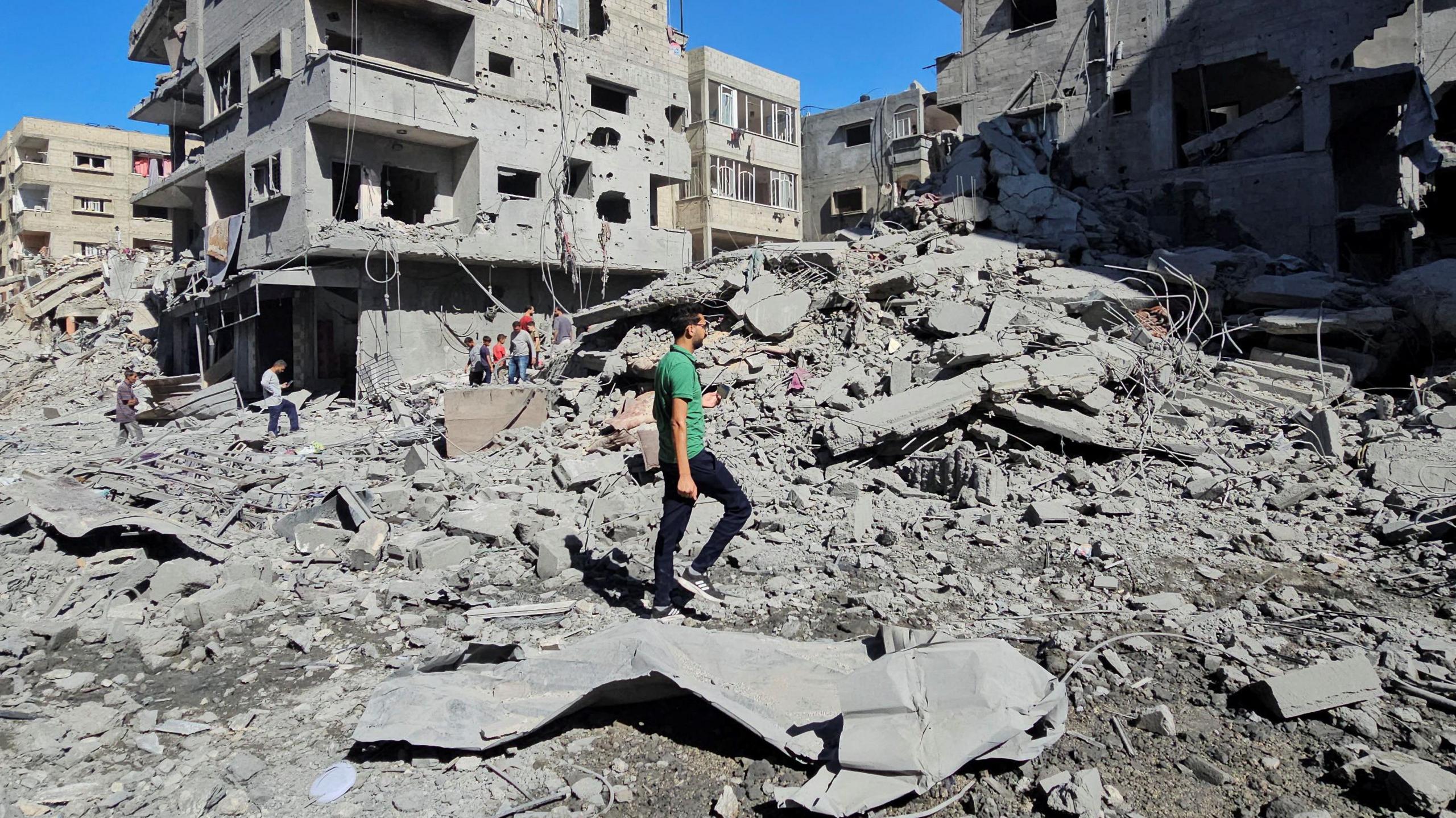 Palestinians gather at the site of Israeli strikes on houses and residential buildings, amid the ongoing Israel-Hamas conflict