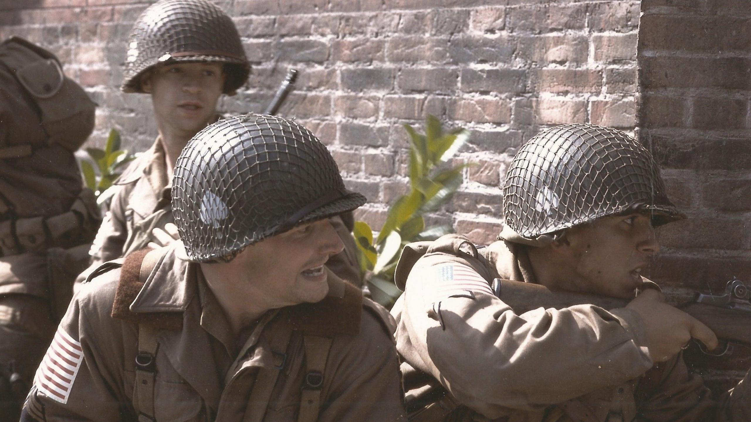 Sabga-Brady, holding an gun leaning round a wall, during a scene in Band of Brothers