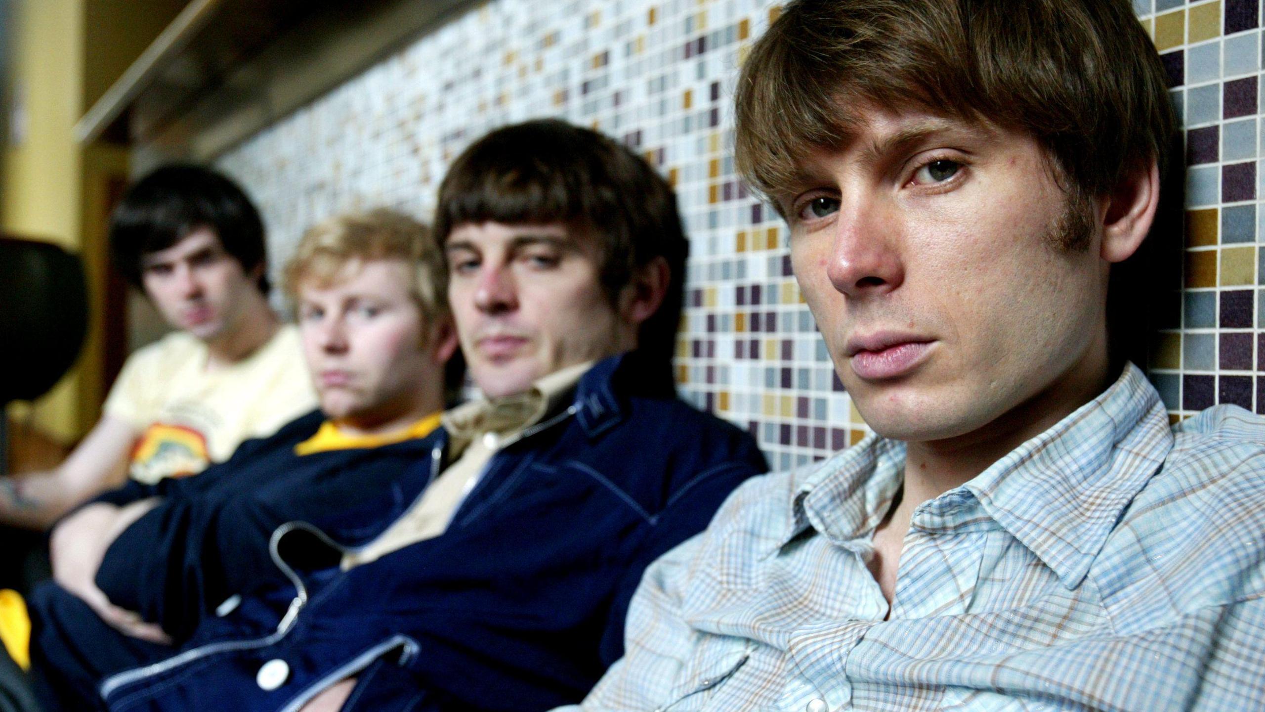 The original line-up of Franz Ferdinand slouched against a wall and looking into the camera on a tour of Australia early in their career. 