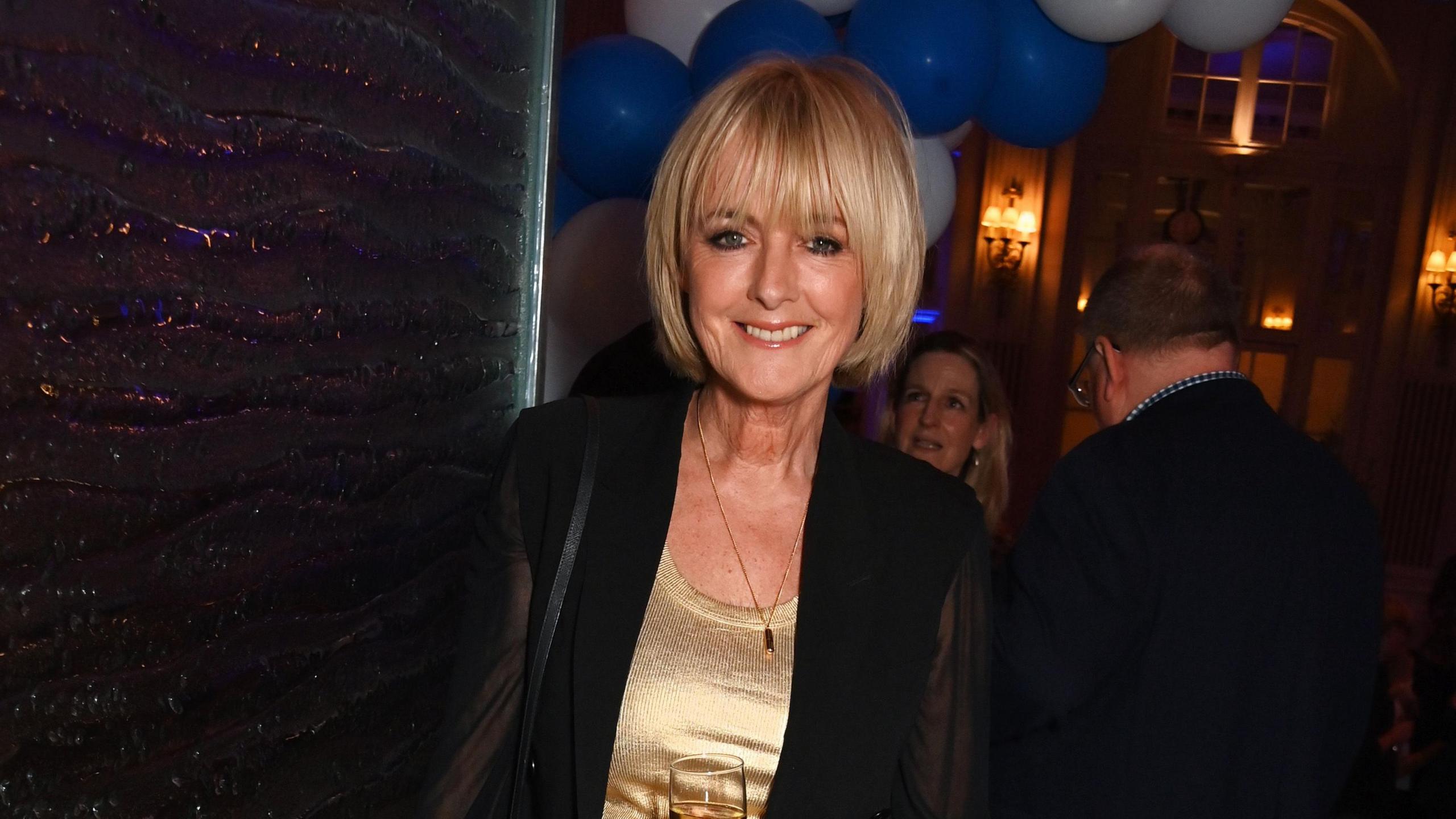 Jane Moore stares into the camera - she is wearing a gold top