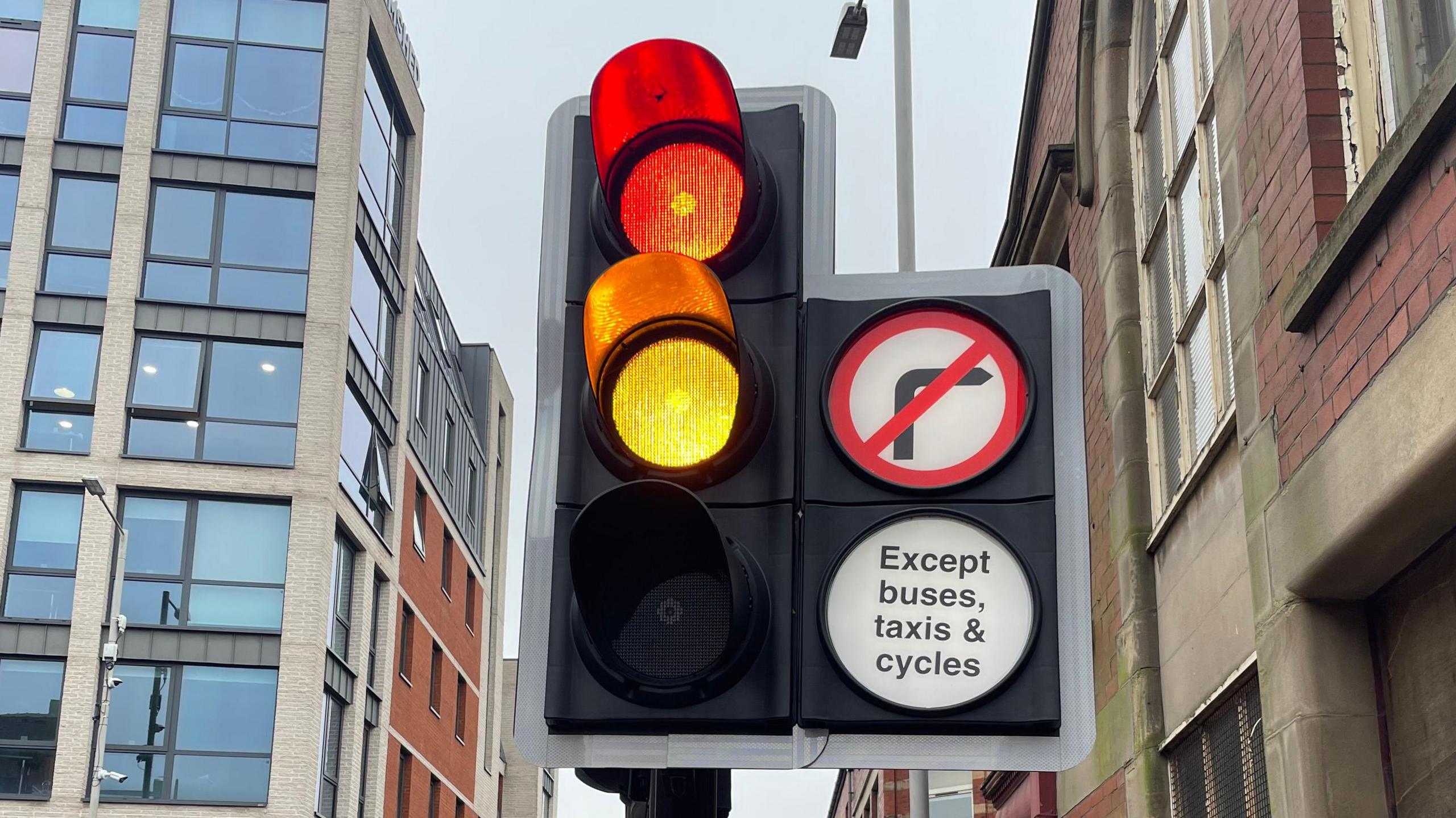 A close-up of a set of traffic lights in Preston with the red and orange lights on