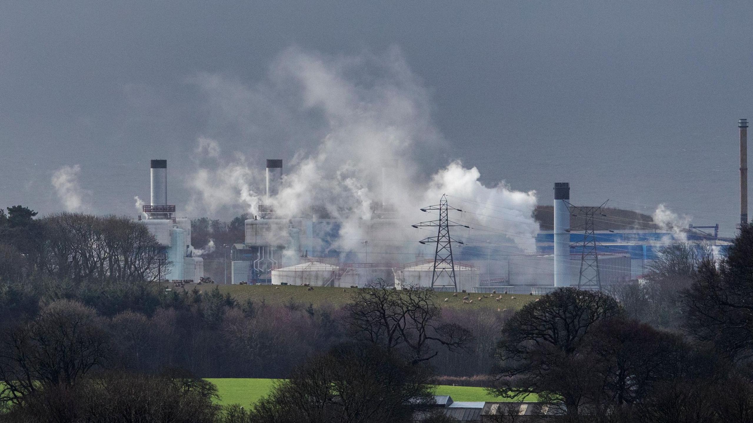 Landscape shop of nuclear plant with smoky clouds in the air. 