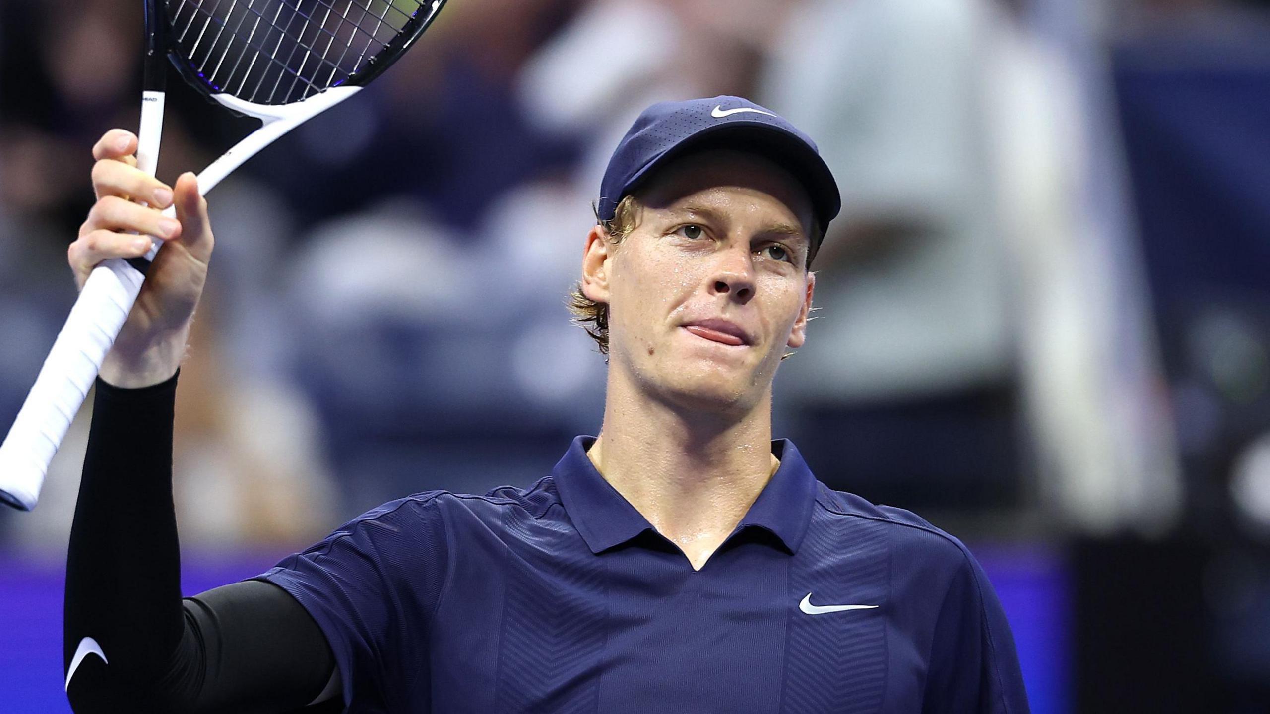 Jannik Sinner raises his racquet to the US Open crowd