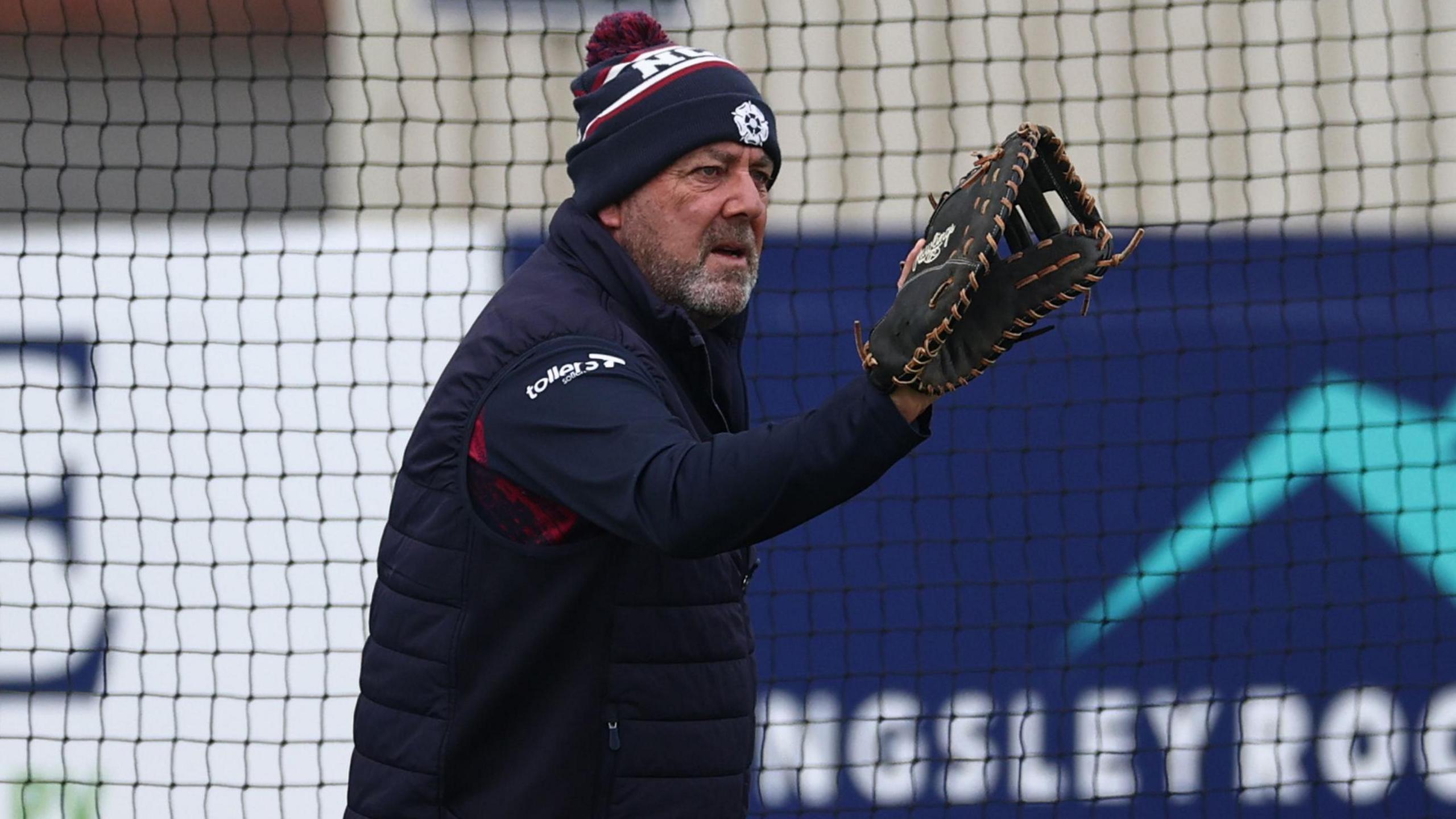 Darren Lehmann prepares to catch a cricket ball while wearing a baseball mitt
