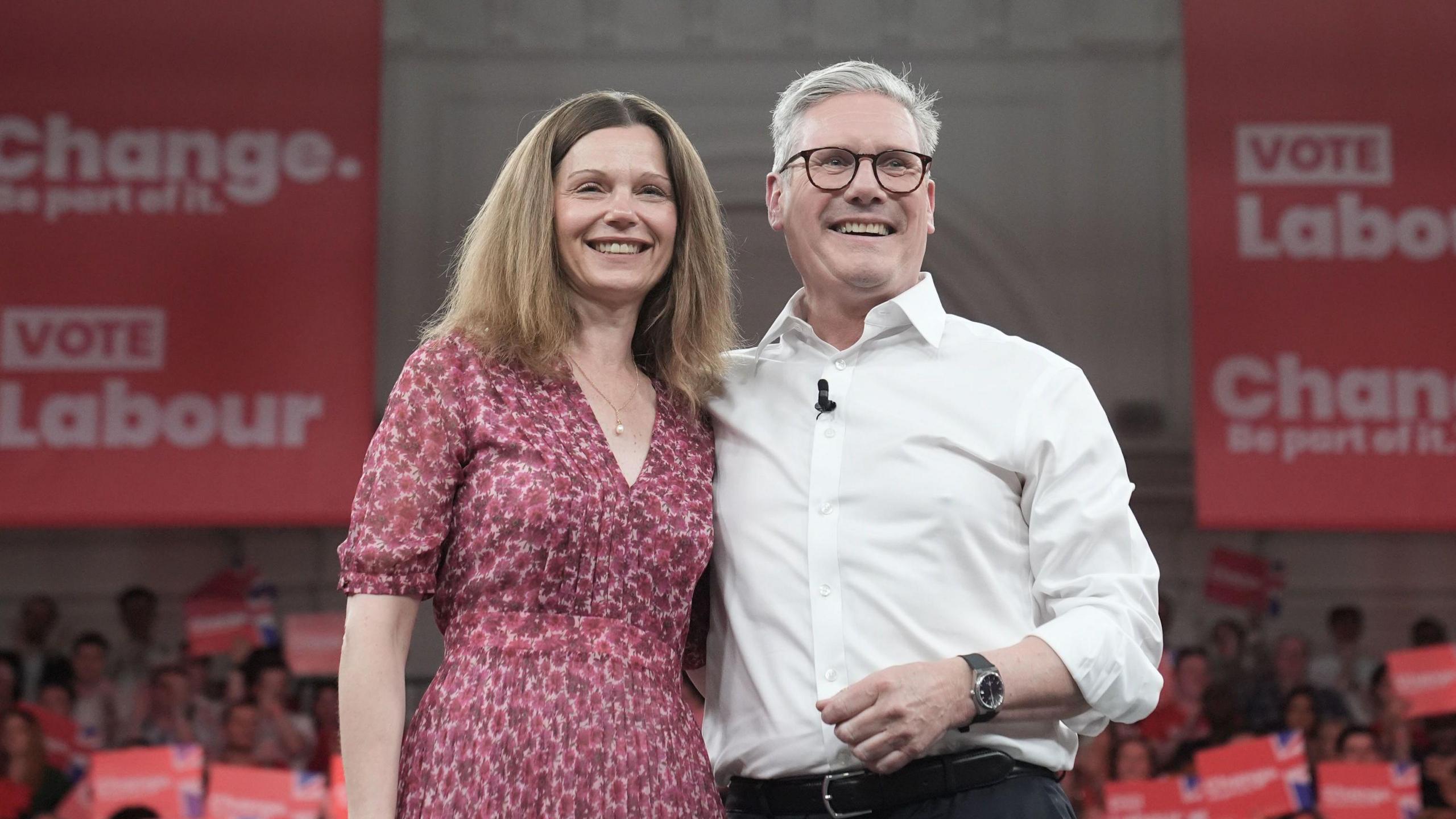 Keir Starmer with his arm around his wife Victoria in front of Labour branding