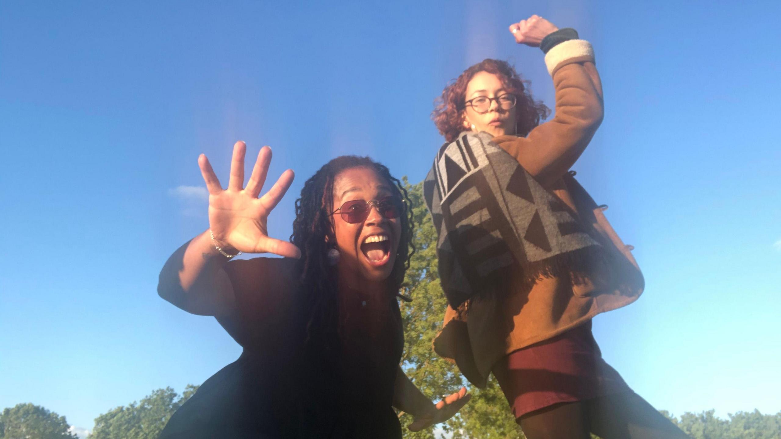 Bibaa Henry and Nicole Smallman pose for the camera in front of a bright blue sky on grass