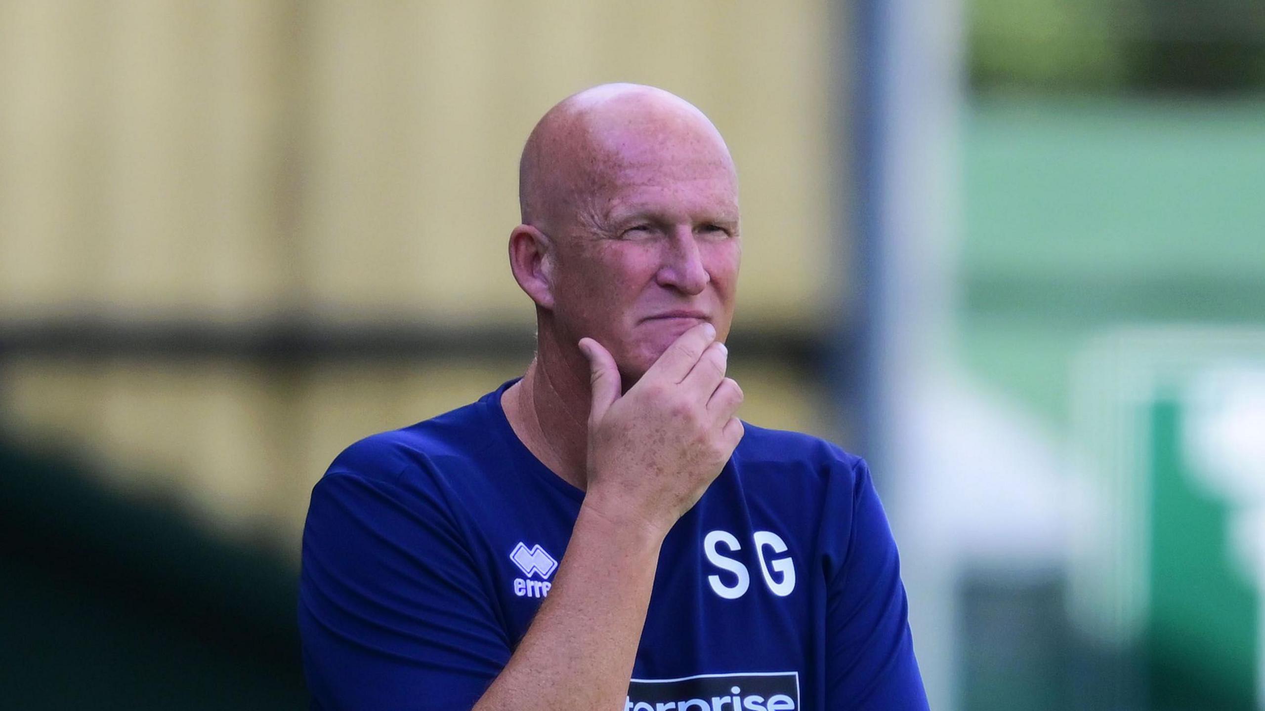 Simon Grayson, pinch his correct manus stroking his chin, watches Hartlepool United play