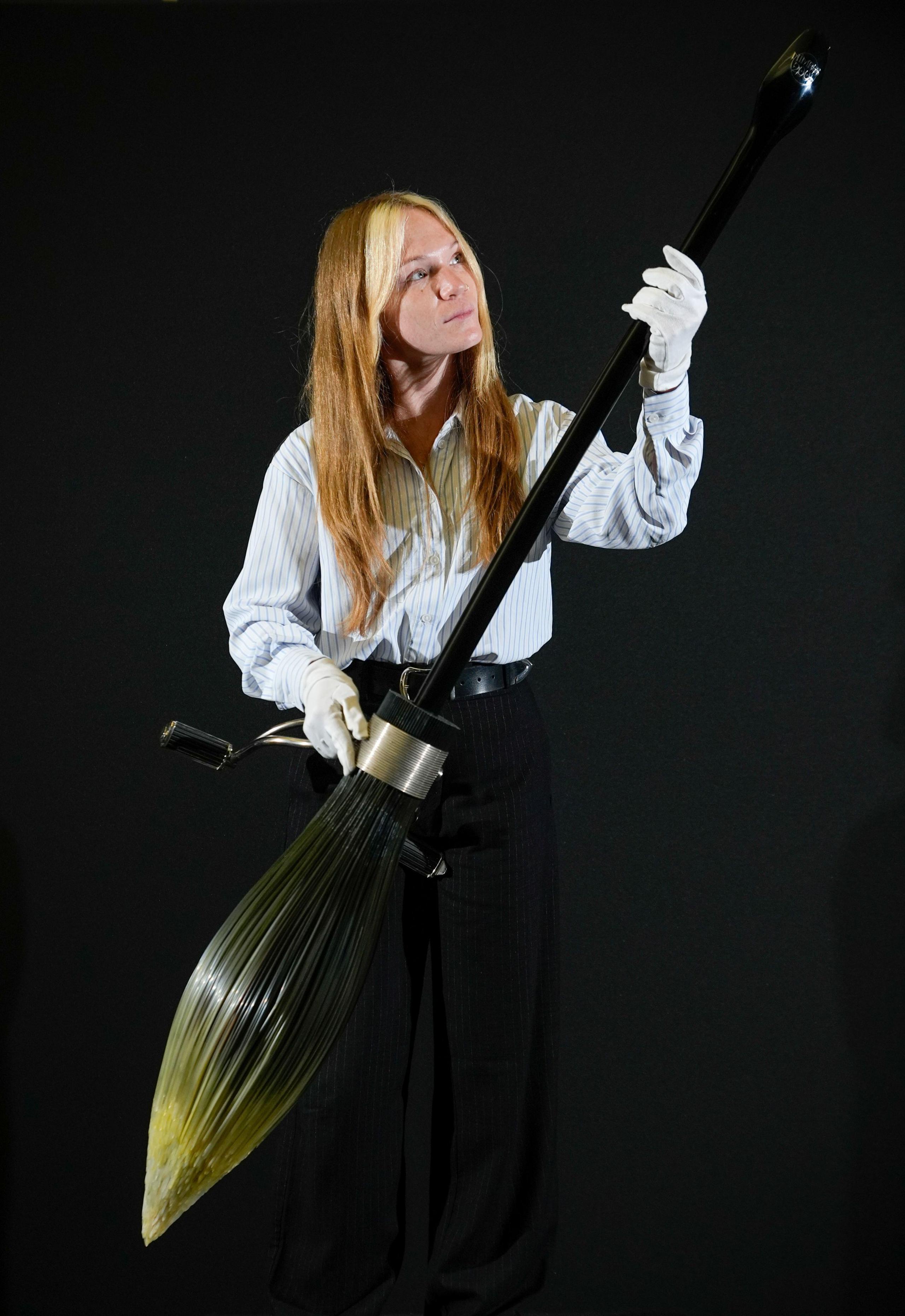 A Propstore employee holds a 'Nimbus 2001' broom from the 2002 film 'Harry Potter and the Chamber of Secrets' (estimate £50,000 - 100,000).