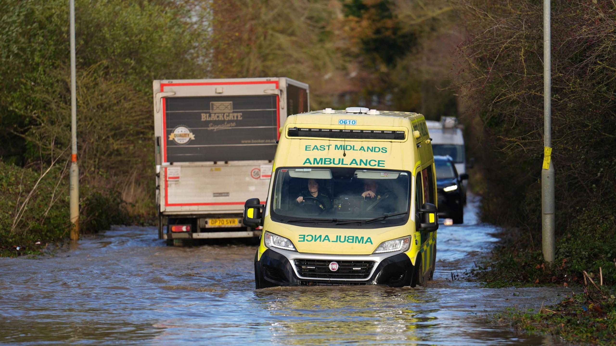 An ambulance drives through floodwater near the Billing Aquadrome in Northamptonshire. 